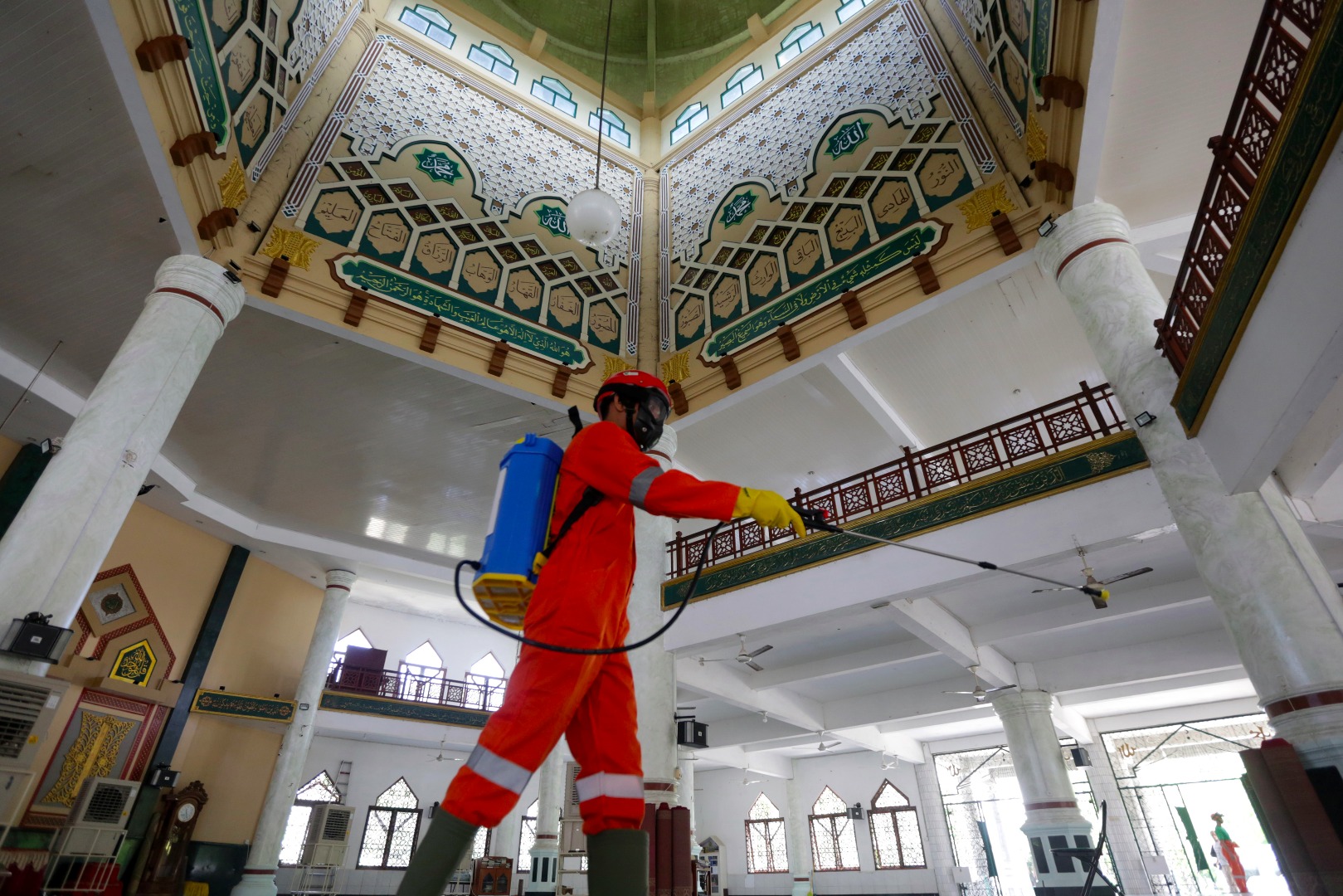 Petugas menyemprotkan cairan desinfektan di Masjid Kupiah Meuketop, Aceh, untuk mencegah penyebaran covid-19.