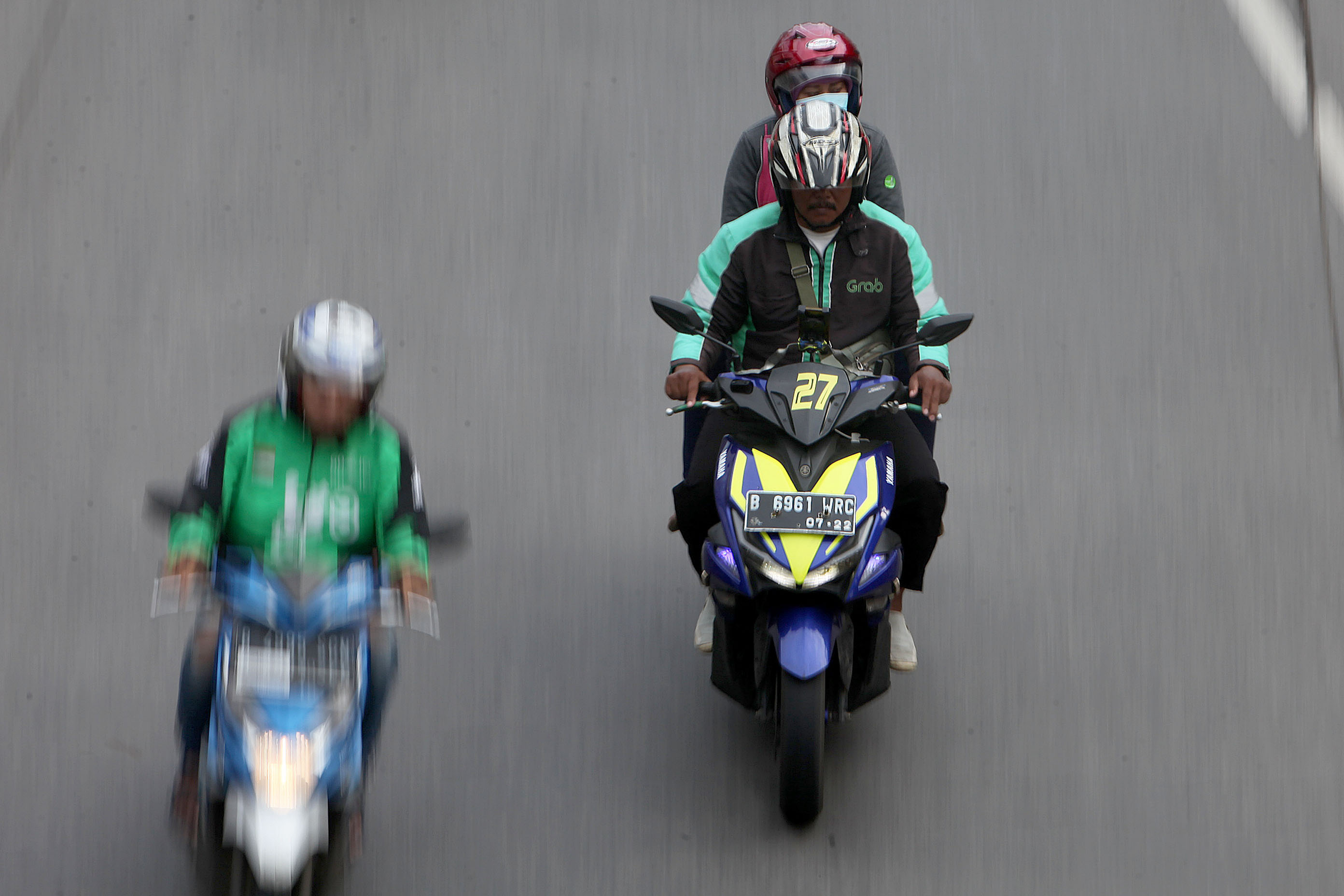 Pengendara ojek daring membawa penumpang saat melintas di kawasan Ragunan, Jakarta Selatan.