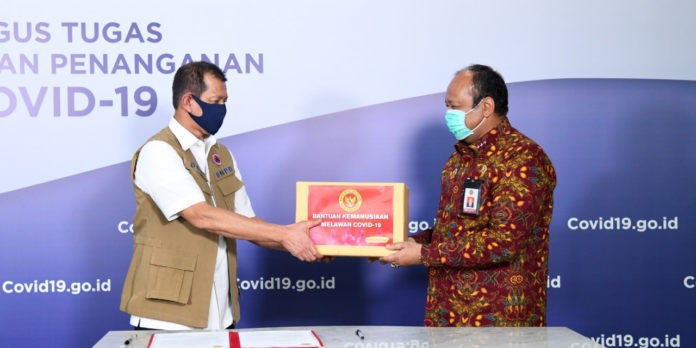 Kepala BNPB Doni Monardo (kiri) menerima bantuan alkes dan APD dari Wakil Kepala BIN Teddy Lhaksmana Widya Kusuma