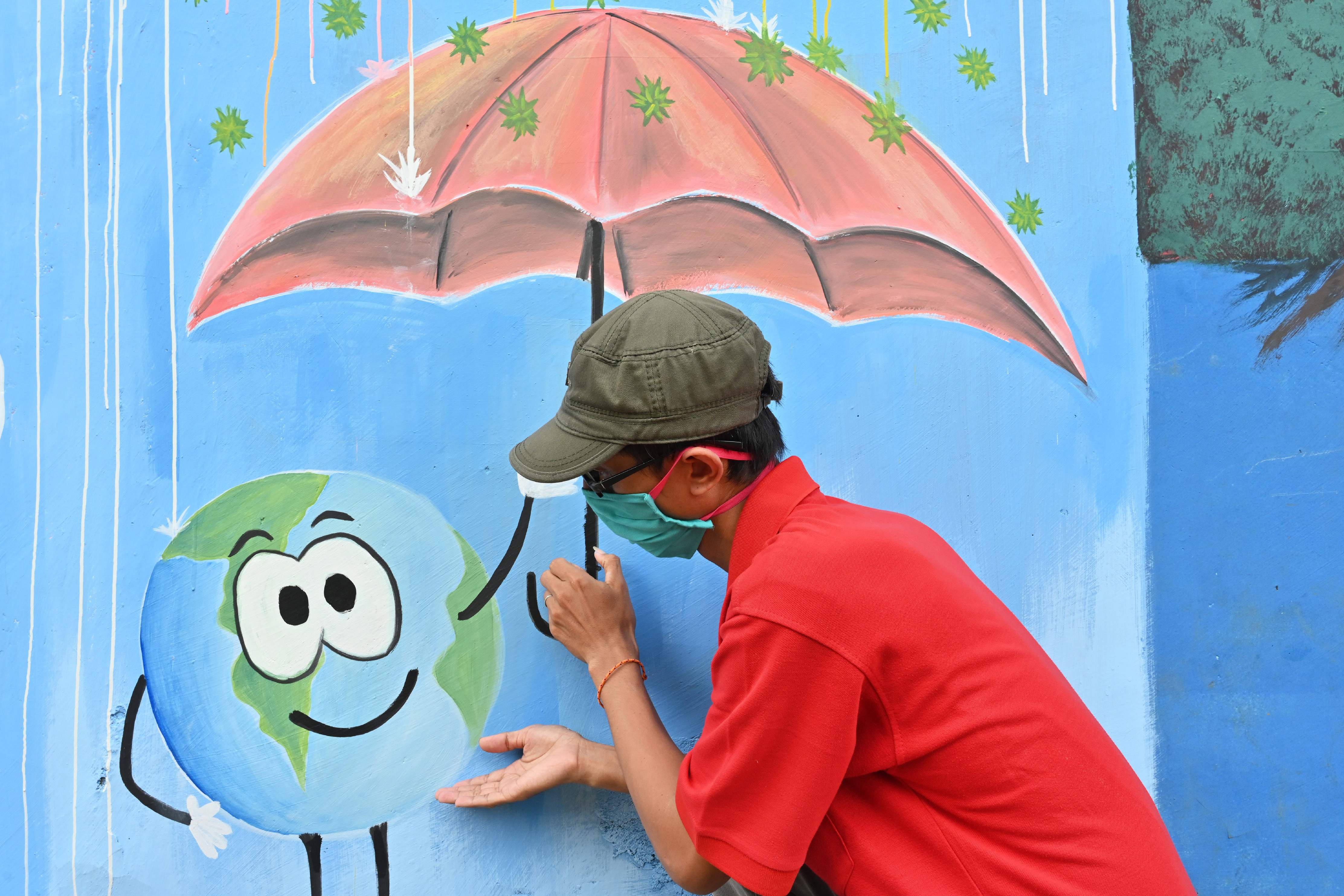 Seorang seniman di Depok, Jawa Barat, menunjukkan hasil karyanya terkait kampanye melawan covid-19.