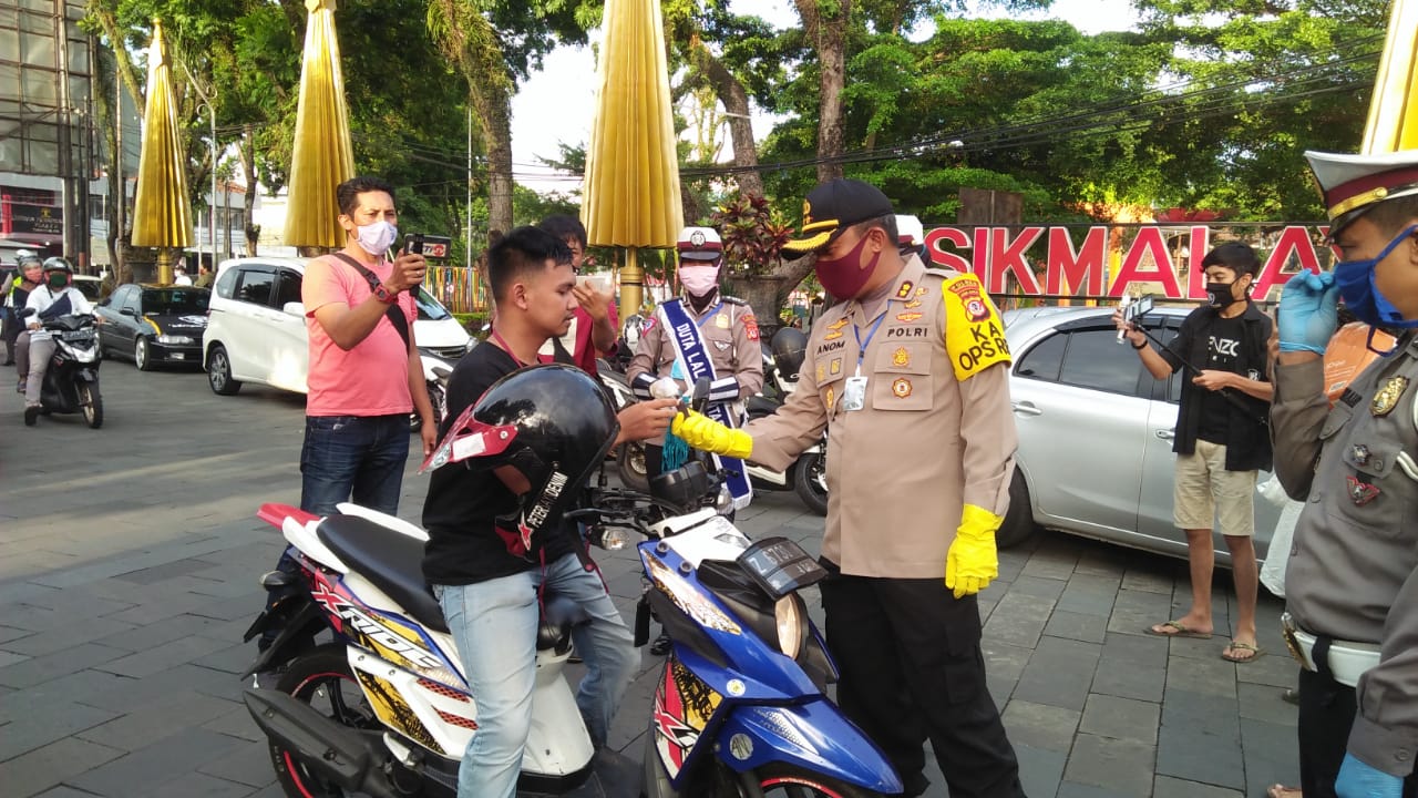 Kapolres Tasikmalaya Kota AKBP Anom Karibinto memberikan masker gratis bagi pengendara motor di Jl HZ Mustofa. 