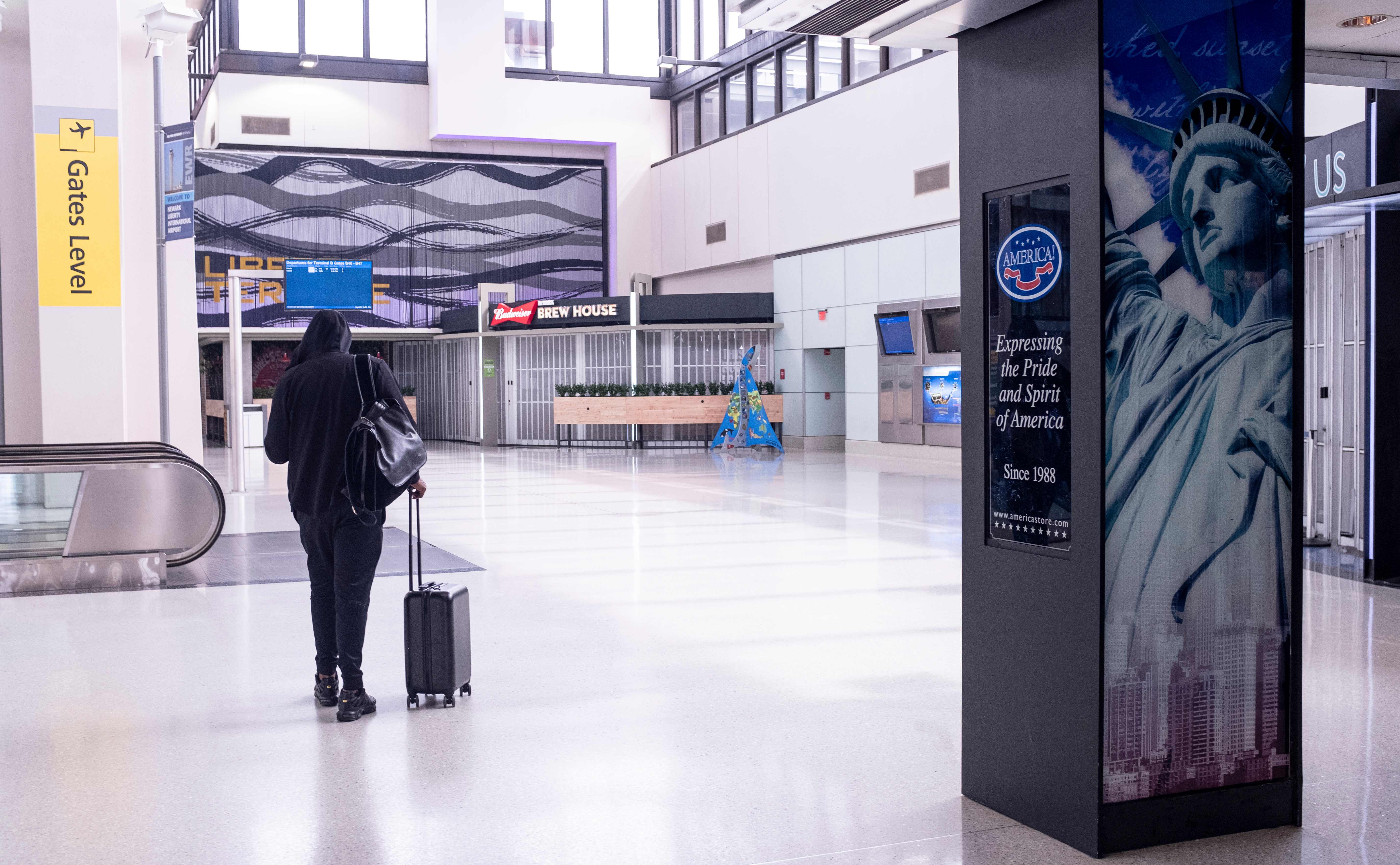 Seorang calon penumpang berjalan di dalam Banda Internasional Newark Liberty, New Jersey, Amerika Serikat.