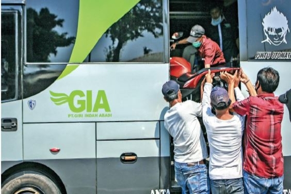 Pekerja menaikkan sepeda motor milik penumpang yang mudik ke dalam bus di Terminal Kalideres, Jakarta, kemarin.