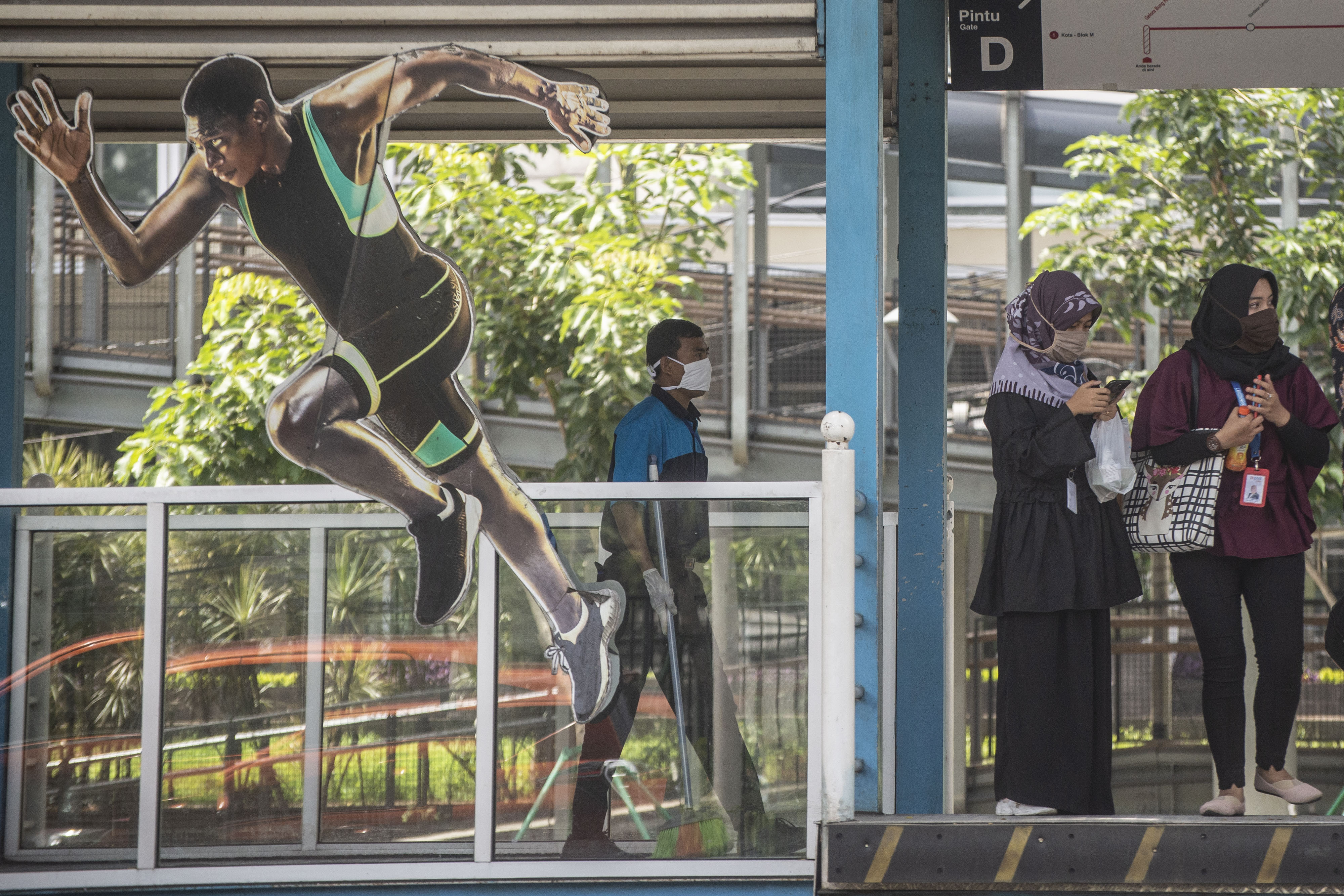 Calon penumpang bus TransJakarta menggunakan masker saat menunggu kedatangan bus di Halte Gelora Bung Karno, Jakarta, Ranu (1/4/2020).
