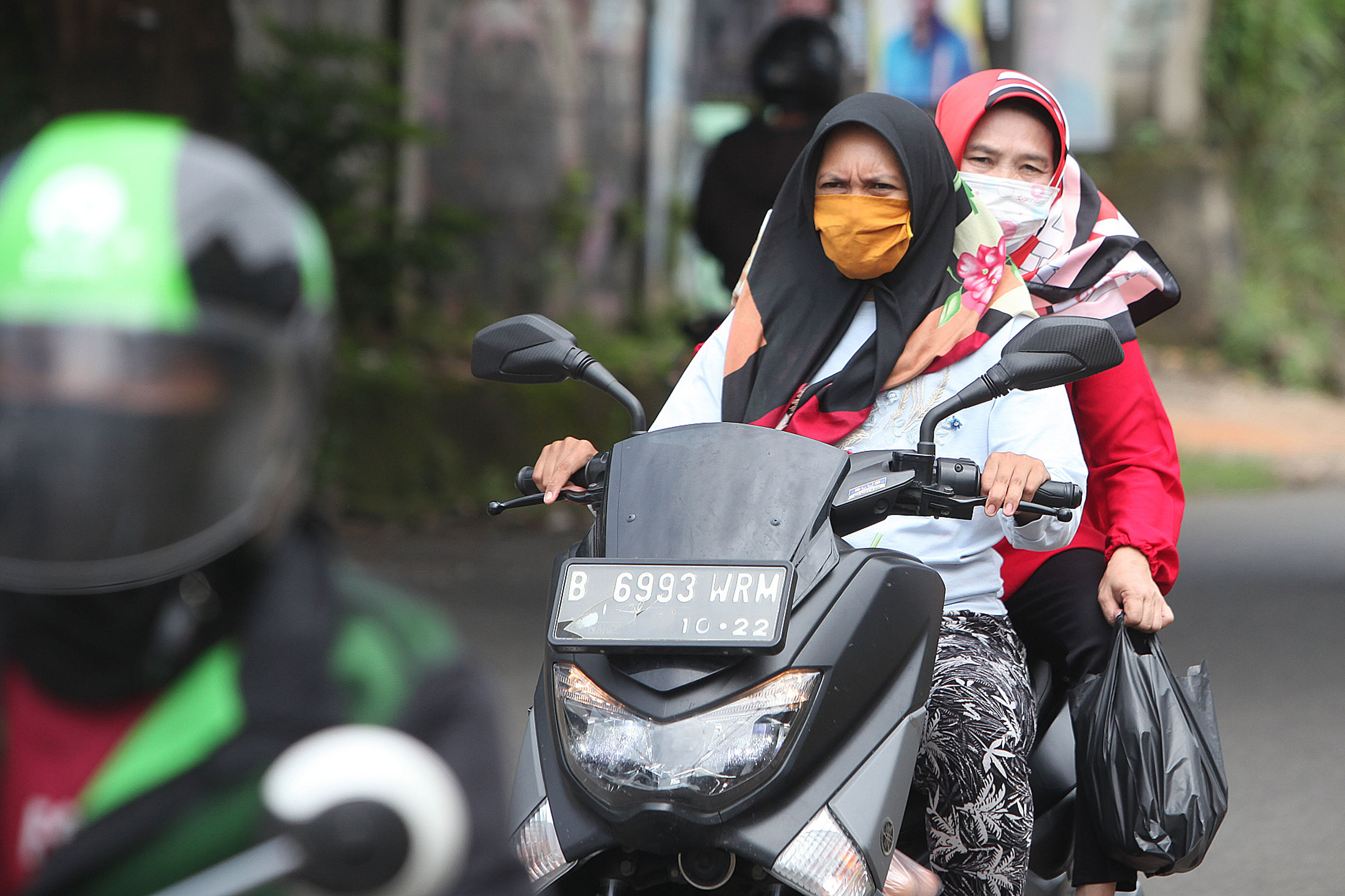 Warga mengenakan masker saat beraktifitas di Jakarta, Senin (06/04/2020). 