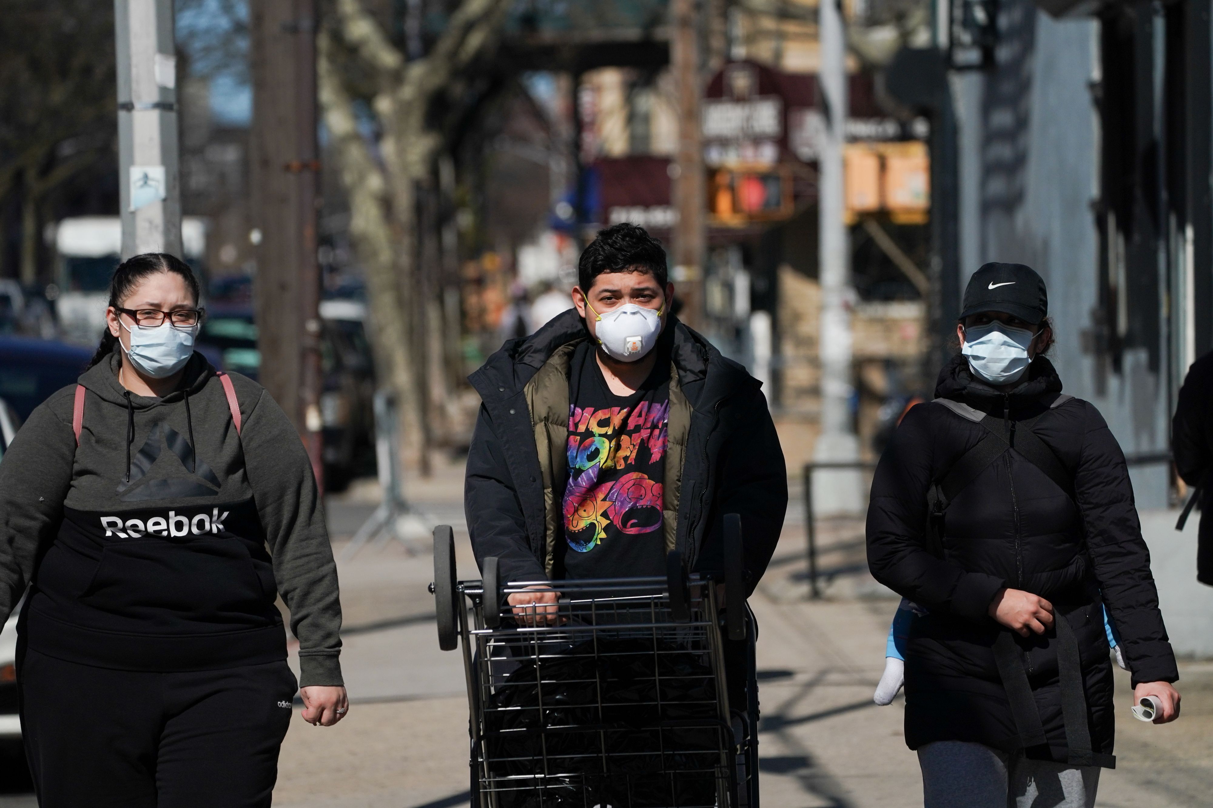 Warga mengenakan masker saat berjalan di luar rumah di Brooklyn, New York, Amerika Serikat.