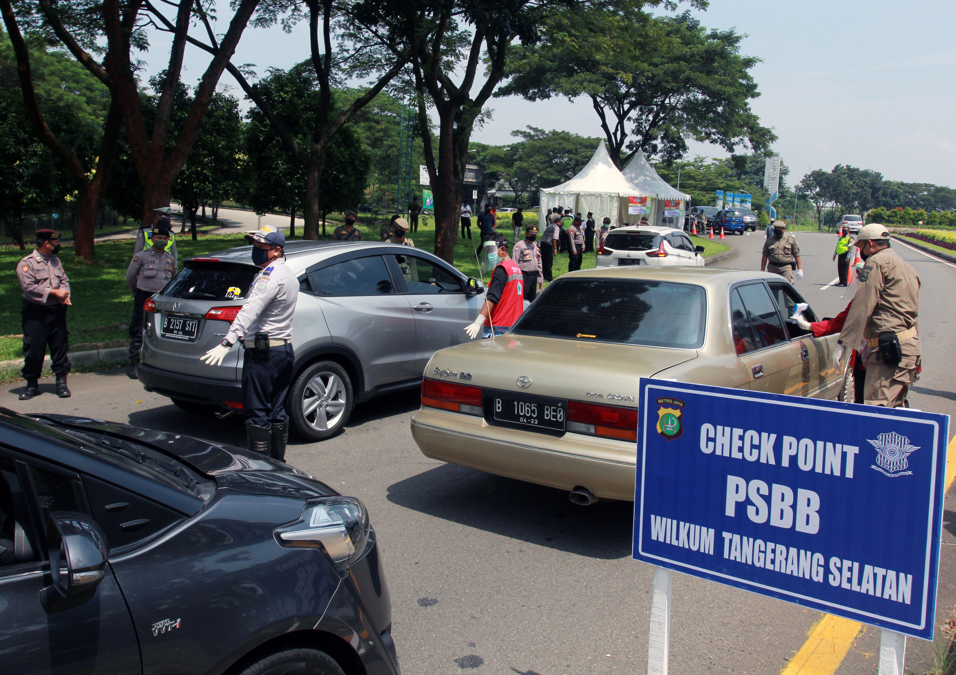 pemeriksaan penumpang dan pengecekan suhu tubuh pengendara dan penumpang mobil yang memasuki wilayah Tangerang Selatan di Bintaro.