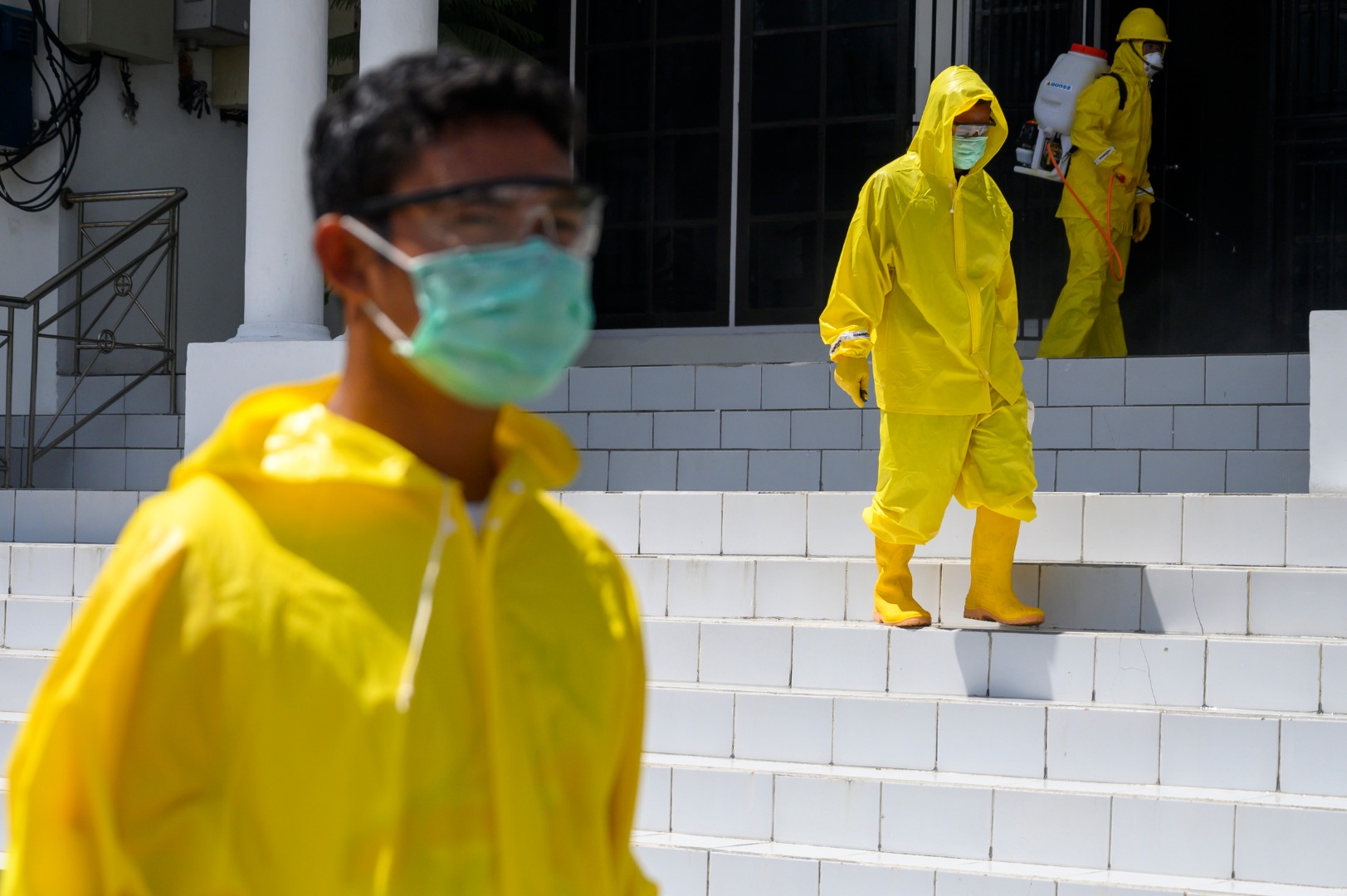Sejumlah relawan Palang Merah Indonesia (PMI) menyemprotkan cairan disinfektan 