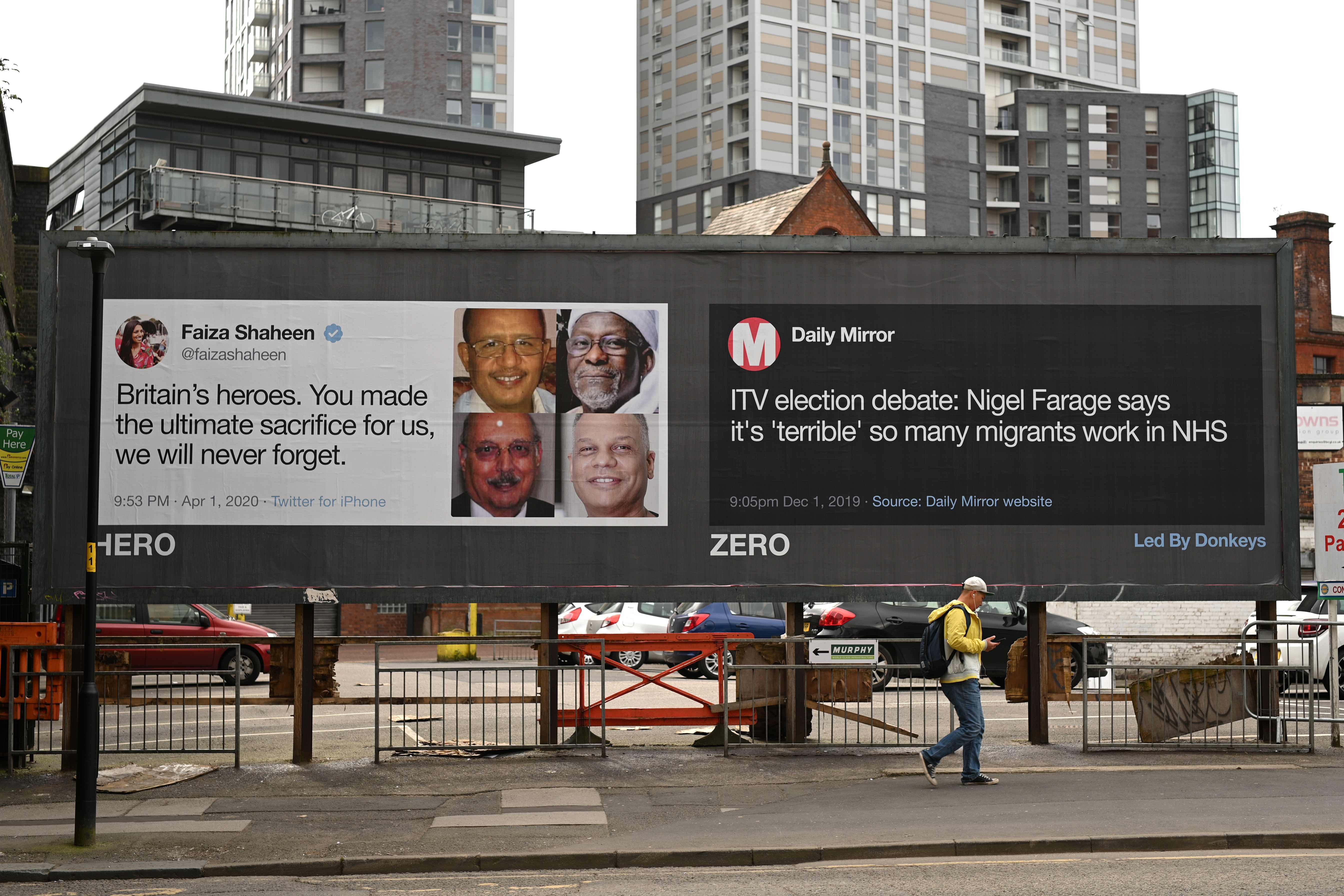 Seorang warga berjalan di depan papan iklan yang mengkritik pernyataan pimpinan oposisi Nigel Farage di Manchester, Inggris.
