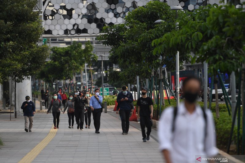 Sejumlah pekerja berjalan usai bekerja dengan latar belakang gedung perkantoran di Jl Jenderal Sudirman, Jakarta, Kamis (16/4).