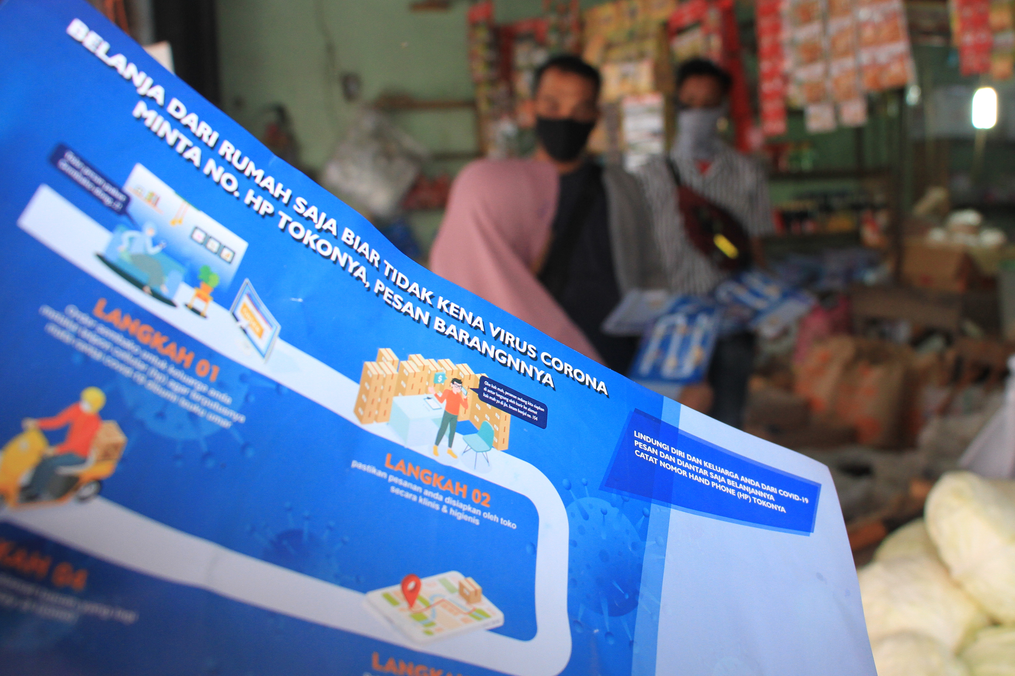 Petugas membagikan brosur sambil mengedukasi pedagang menerapkan belanja melalui media daring di Pasar Bina Usaha, Meulaboh, Aceh Barat.