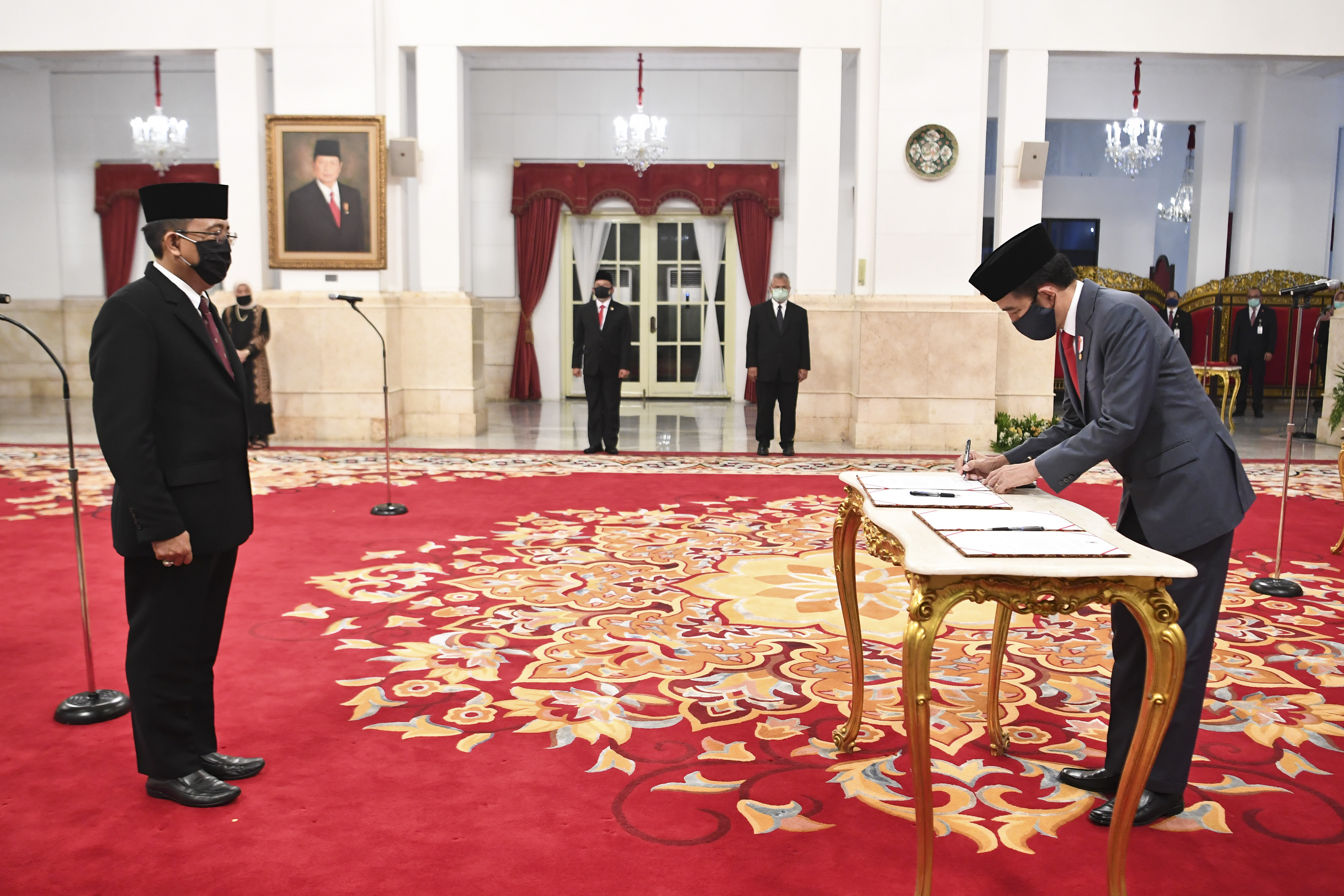 Presiden Joko Widodo (kanan) menandatangani berkas pelantikan Komisioner KPU RI I Dewa Kade Wiarsa Raka Sandi di Istana Negara, Jakarta.