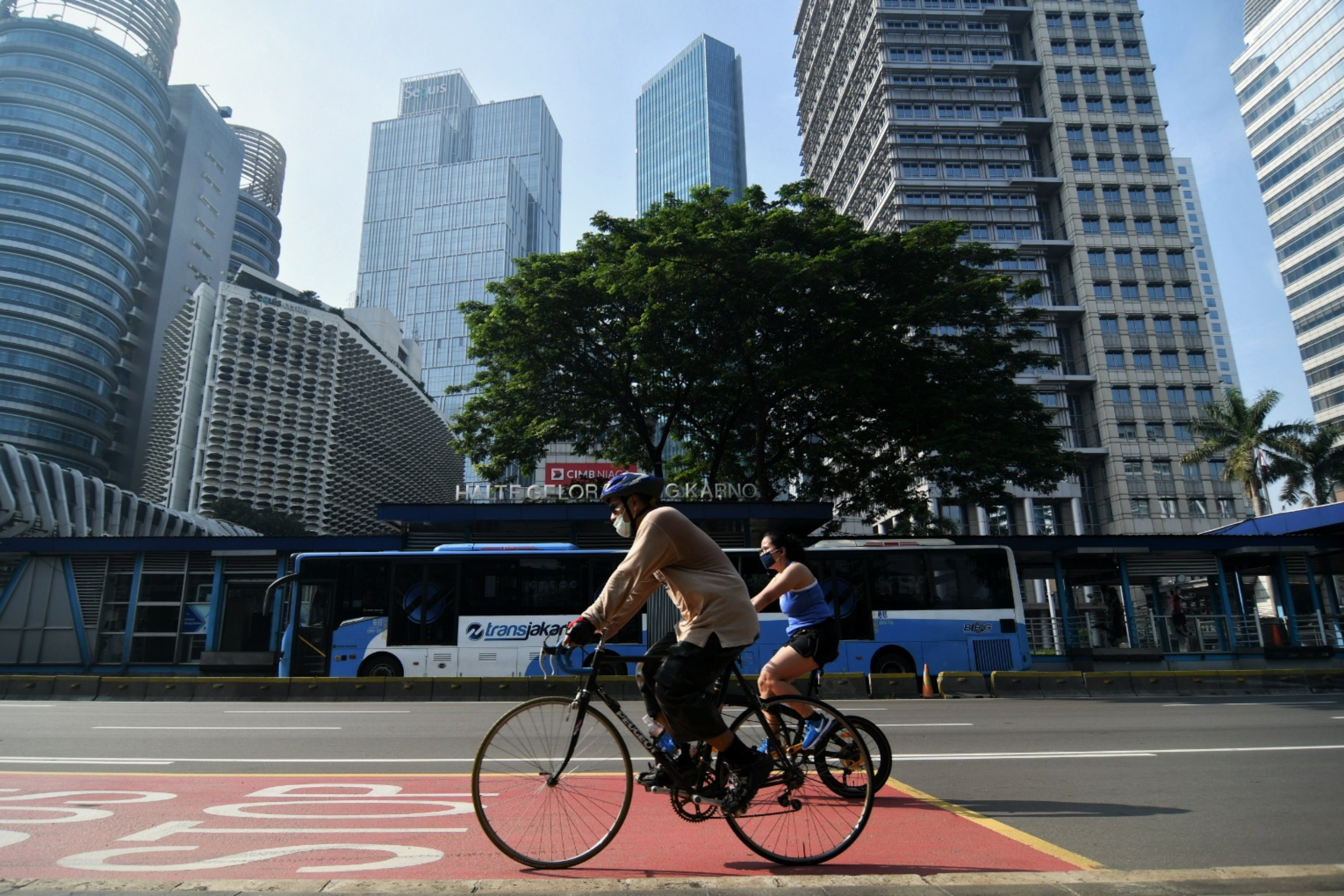 Pesepeda melintasi Jalan Jenderal Sudirman, Jakarta, yang sepi kendaraan di tengah pemberlakuan PSBB.