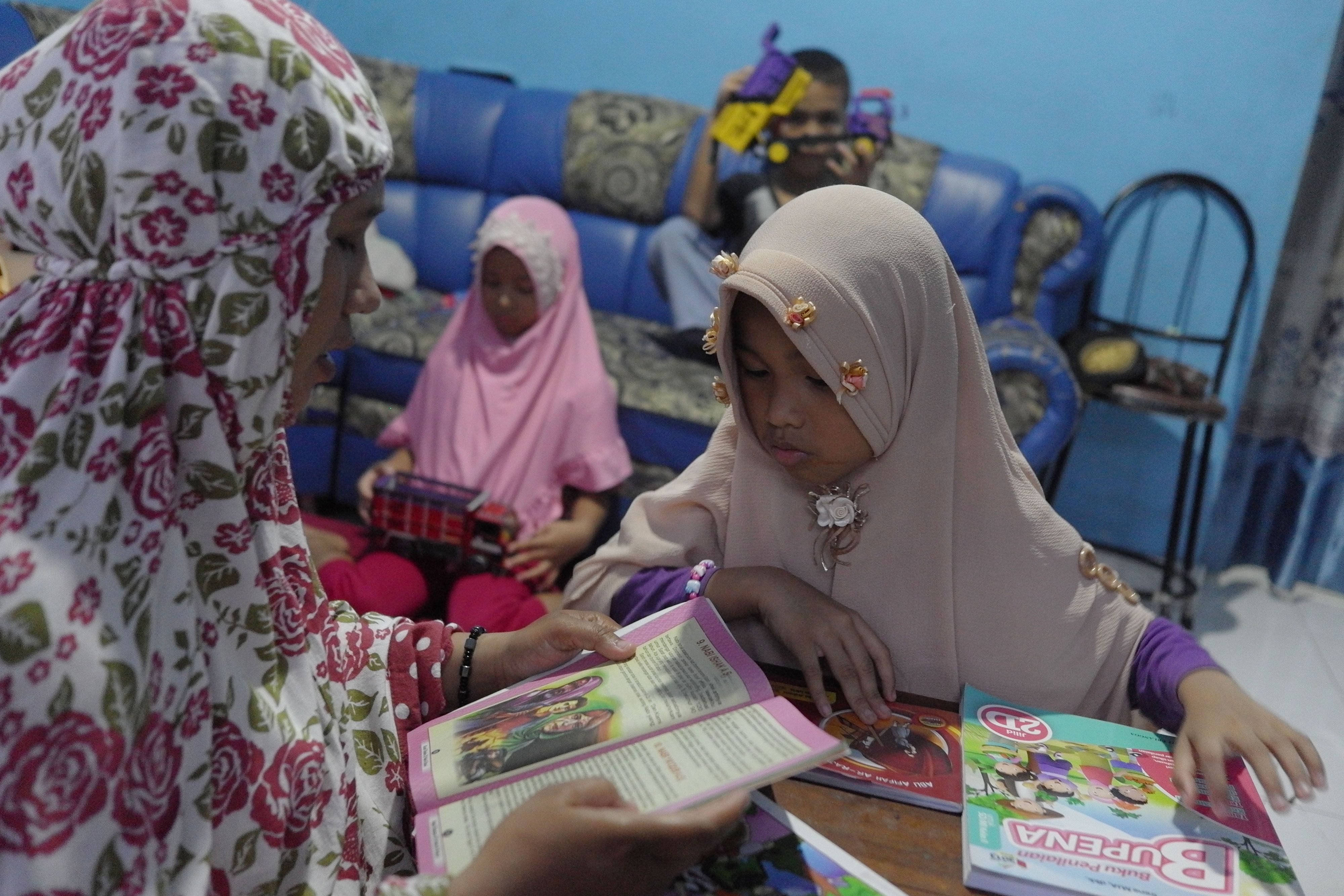 Siswa SD belajar membaca dongeng didampingi ibunya saat pemberlakuan belajar di rumah di Solo, Jawa Tengah, Jumat (10/4/2020).