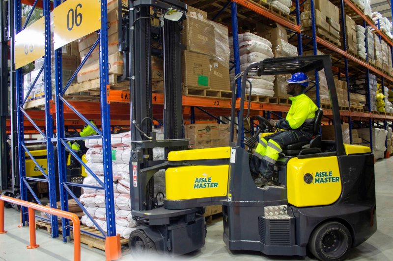 Seorang pekerja mengendarai mesin pengangkat barang di dalam gedung platform logistik DP World di Kigali, Rwanda.