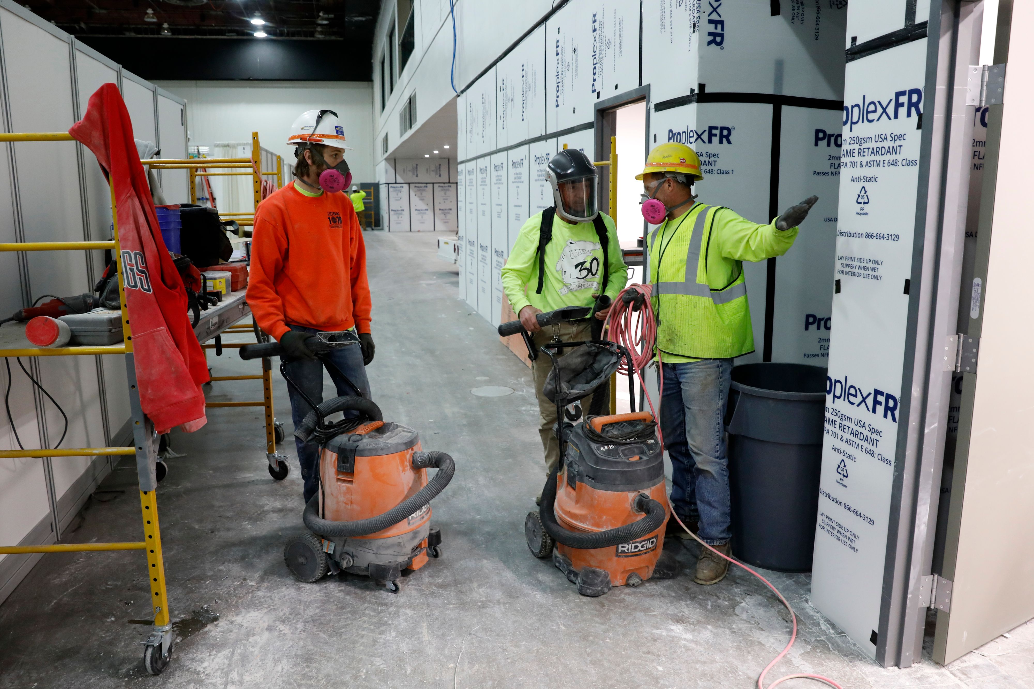 Sekelompok pekerja terlibat dalam proyek mengubah sebuah gedung pertemuan di Detroit, AS, menjadi sebuah rumah sakit darurat.