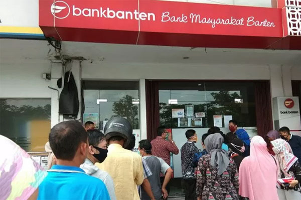 Para nasabah bank Banten mengantre untuk menarik uang di KCP Bank Banten Palima di Kota Serang, Kamis (23/4/2020). 