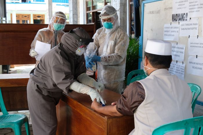Petugas kesehatan melakukan rapid test kepada seorang anggota Jamaah Tabligh di Mojotengah, Kedu, Temanggung, Jateng, Senin (20/4/2020).