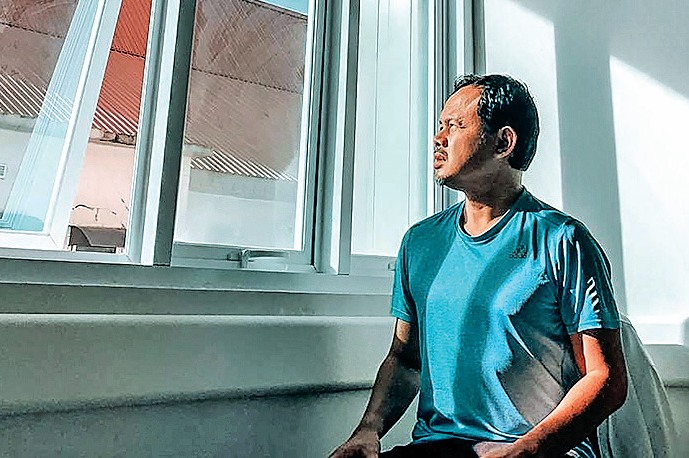 Wali Kota Bogor Bima Arya berjemur di dekat jendela ruang isolasi RSUD Kota Bogor, Jawa Barat, Jumat (10/4/2020).