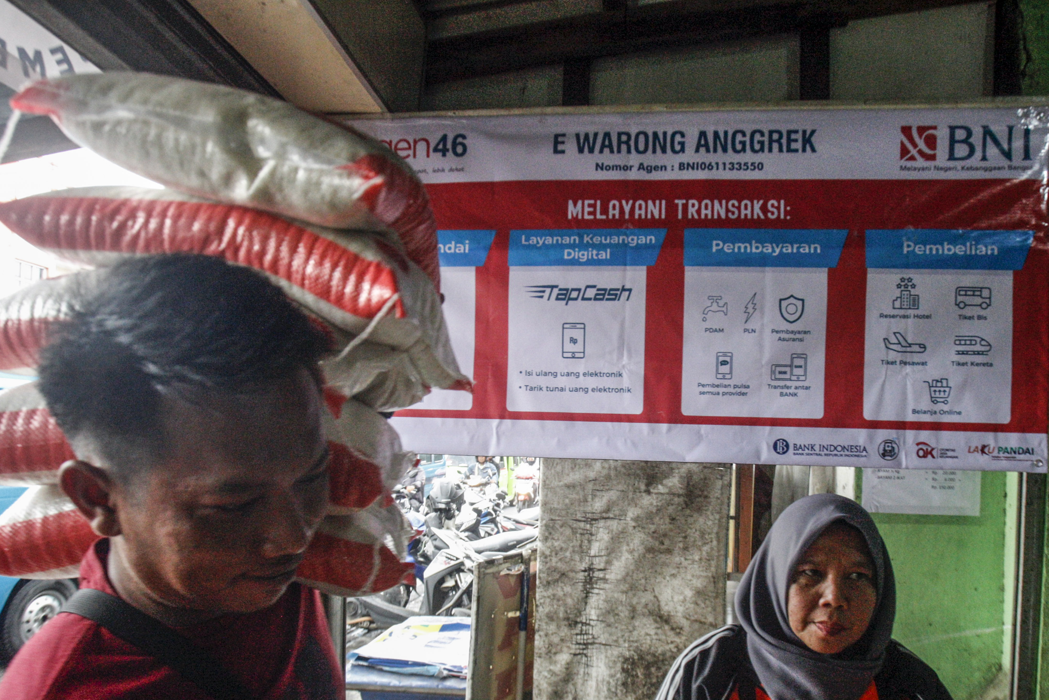 Warga membawa tumpukan beras di e-Warong. Mereka bagian dari PKH yang menerima bantuan sosial. 