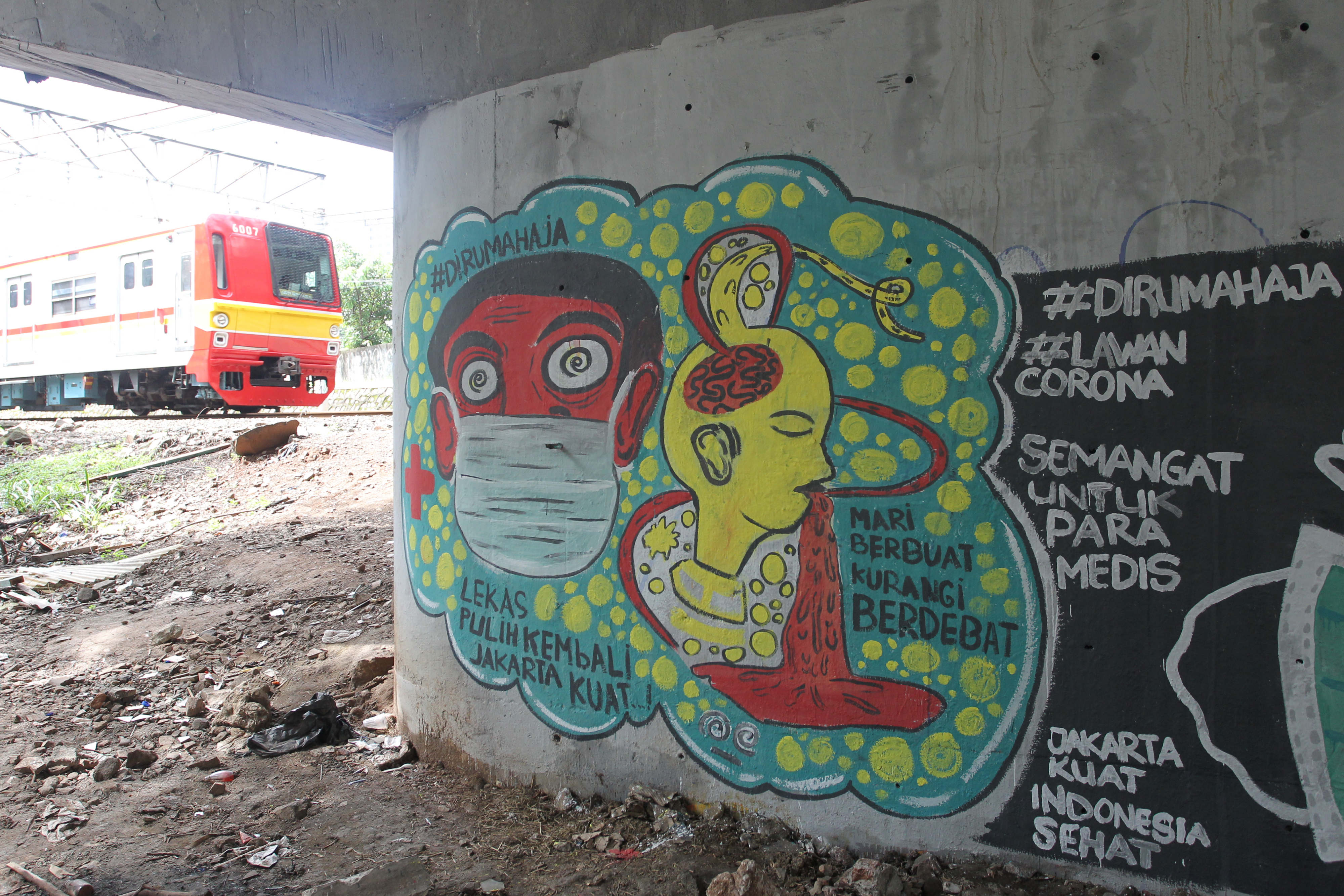 Warga melintasi mural ajakan untuk menggunakan masker dan tetap di rumah di kolong Jalan Rasuna Said, Jakarta, Rabu (1/4).