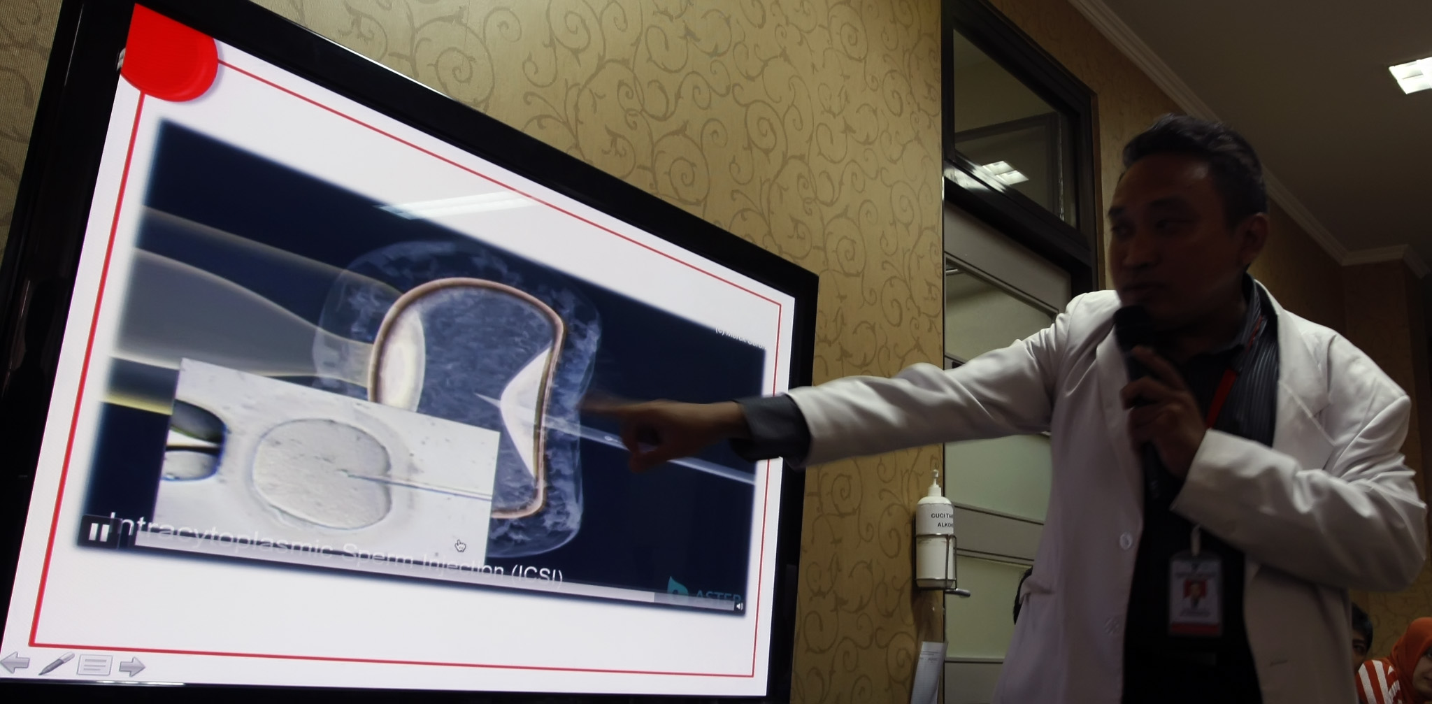 Seorang dokter memperlihatkan cara memasukkan sperma ke dalam sel telur dalam diskusi program bayi tabung.