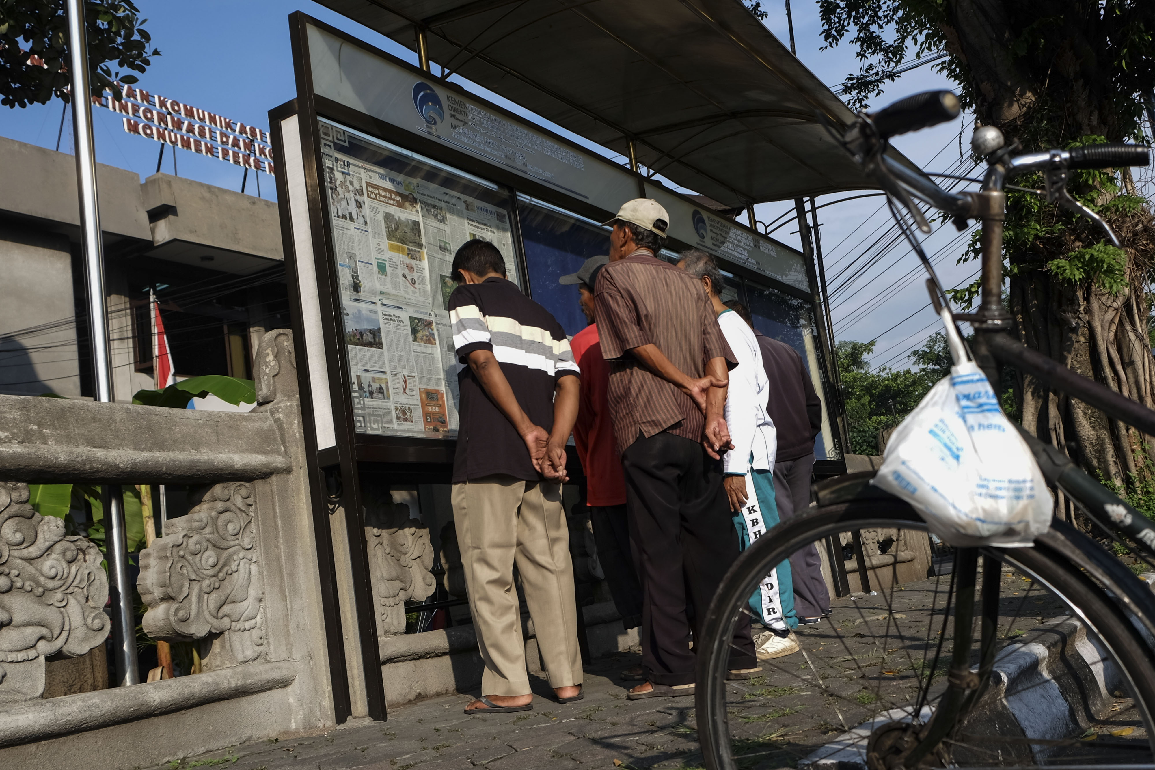 Warga membaca koran di papan pengumuman. Di tengah pandemi korona, bisnis surat kabar di Sumut lesu dan nyaris gulung tikar.