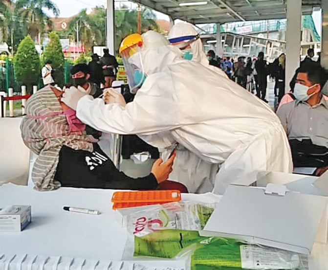 Petugas medis mengambil sampel dari penumpang KRL commuter line saat tes swab di Stasiun Bogor, Jawa Barat.