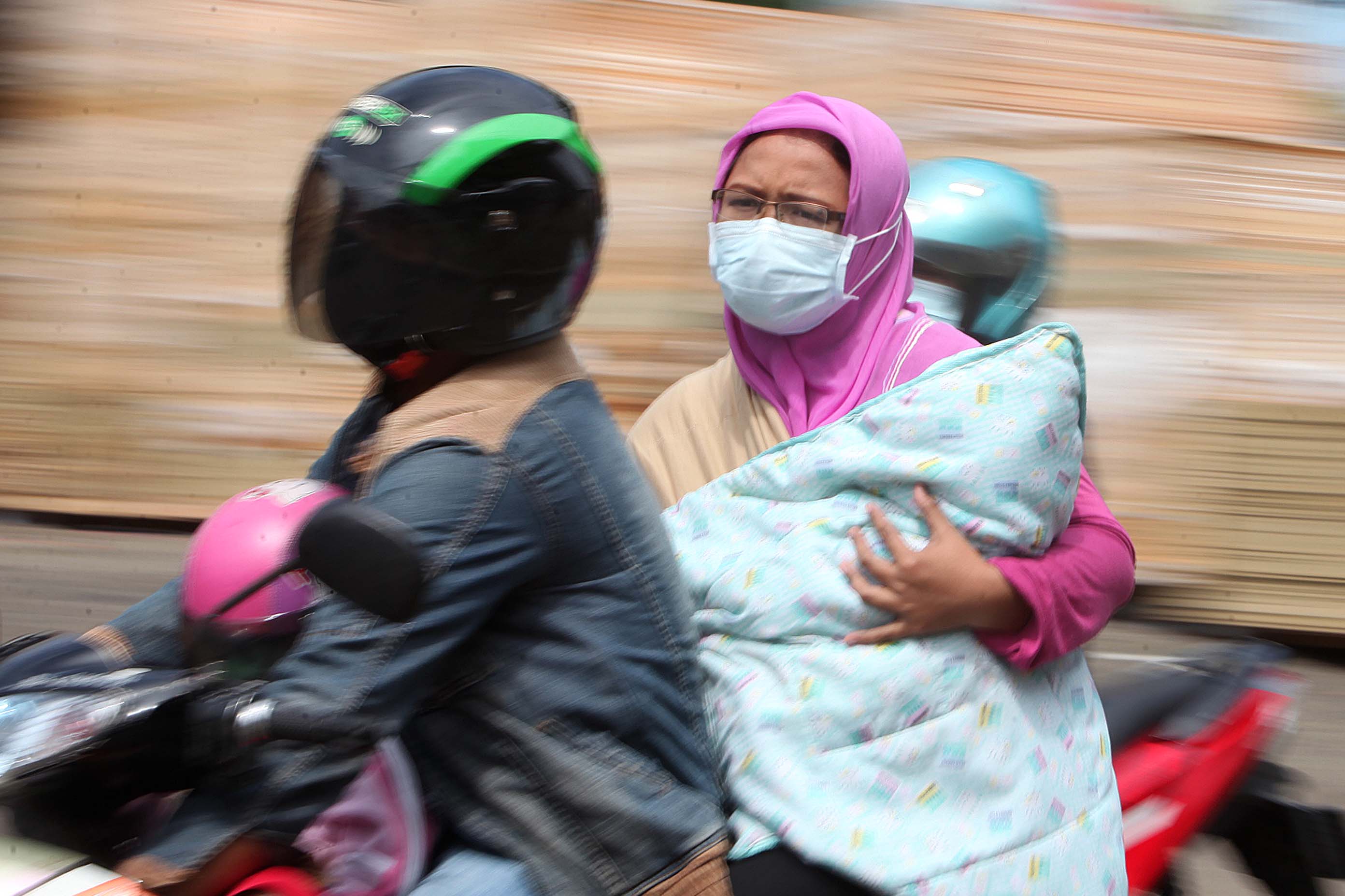 Warga mengenakan masker saat beraktivitas di Jakarta, Senin (06/4).