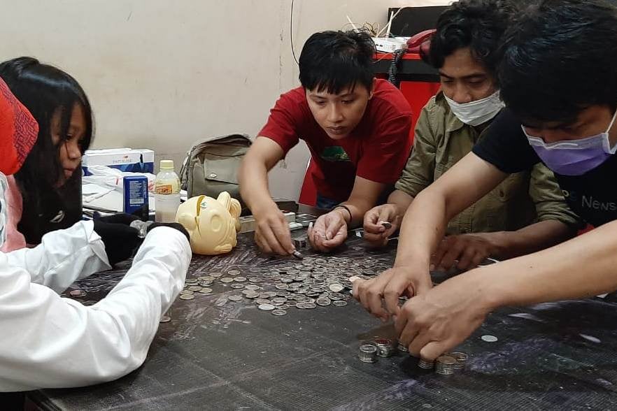 Yasim Saman Ahmad, ibunya, sedang menghitung koin yang disumbangkan untuk penanganan virus korona