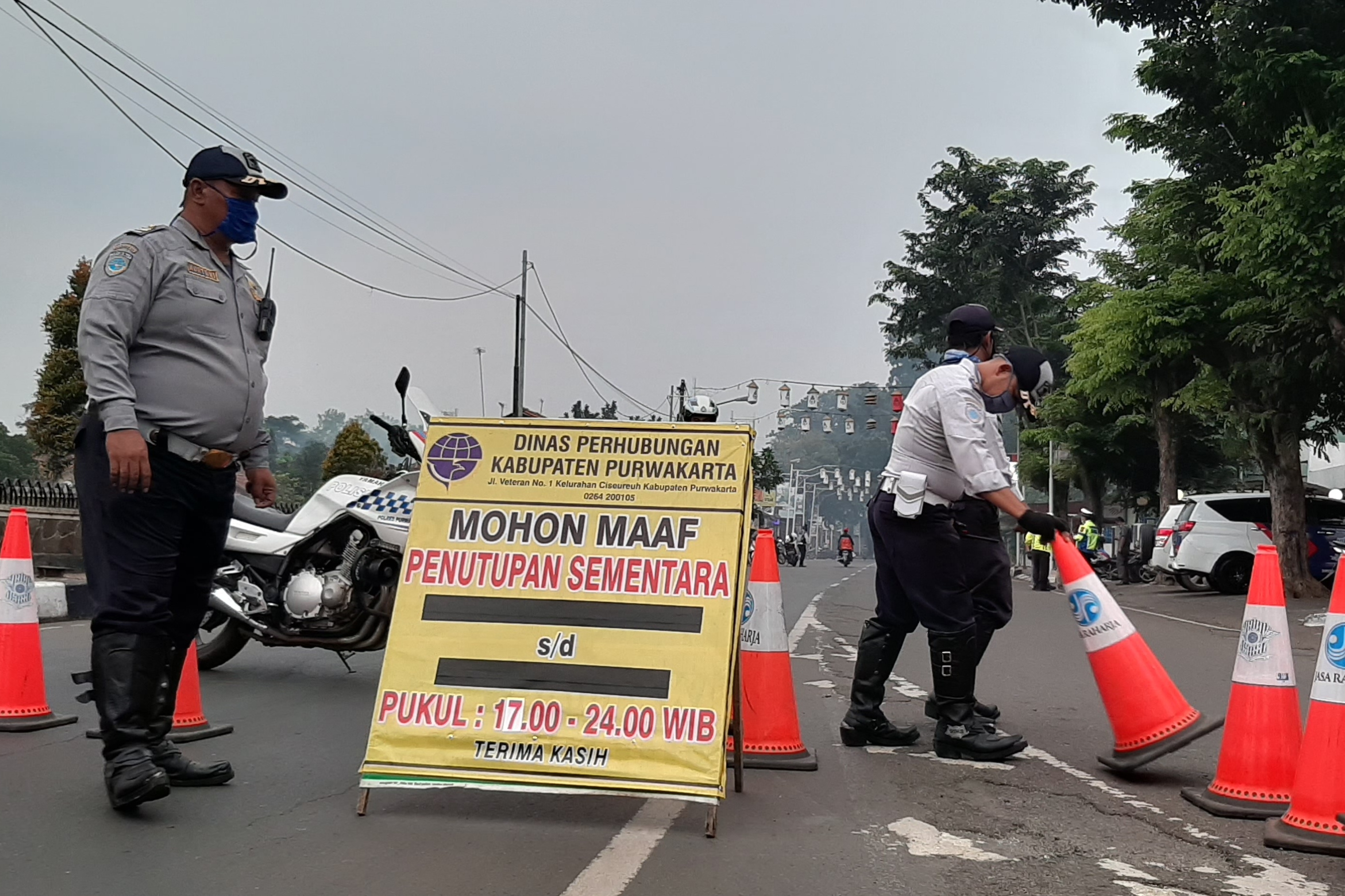 Petugas menutup ruas jalan arteri di Purwakarta, Jawa Barat. 