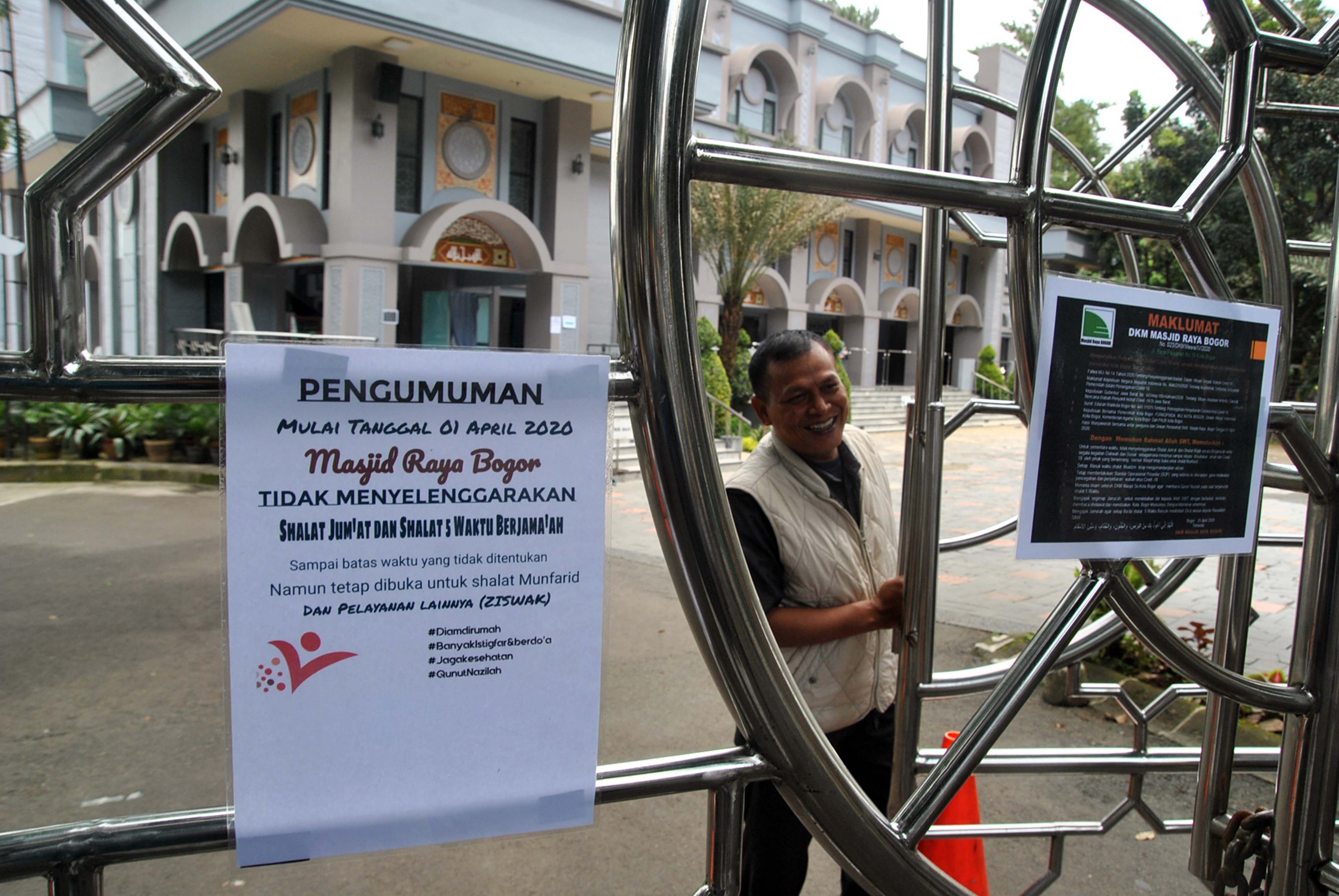 Petugas menutup pintu gerbang masuk di Masjid Raya, Kota Bogor, Jawa Barat meskipun pemerintah kota belum menetapkan PSBB.
