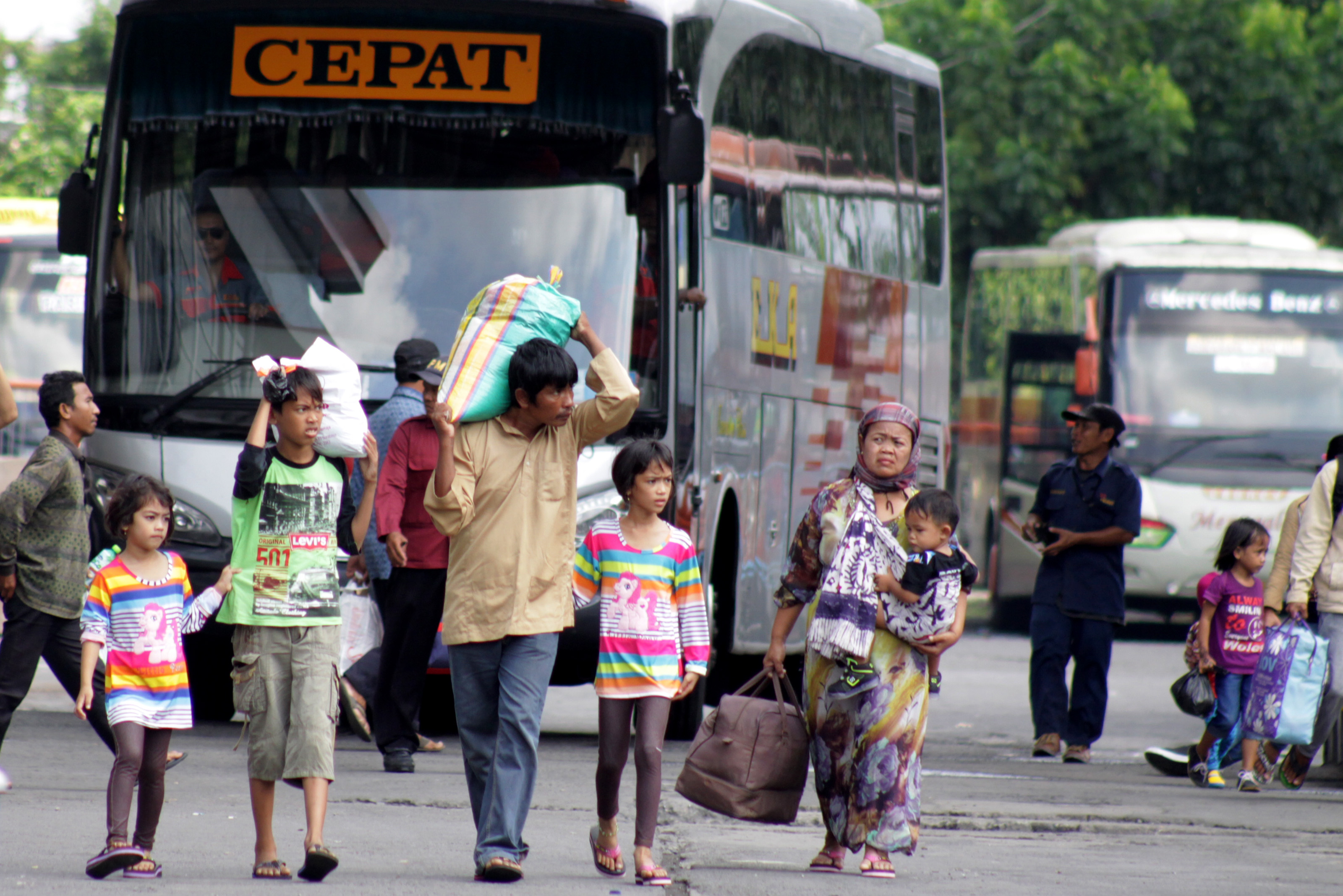  Penumpang membawa barang bawaan di Terminal Purabaya (Bungurasih), Sidoarjo, Jawa Timur, Minggu (3/7). 