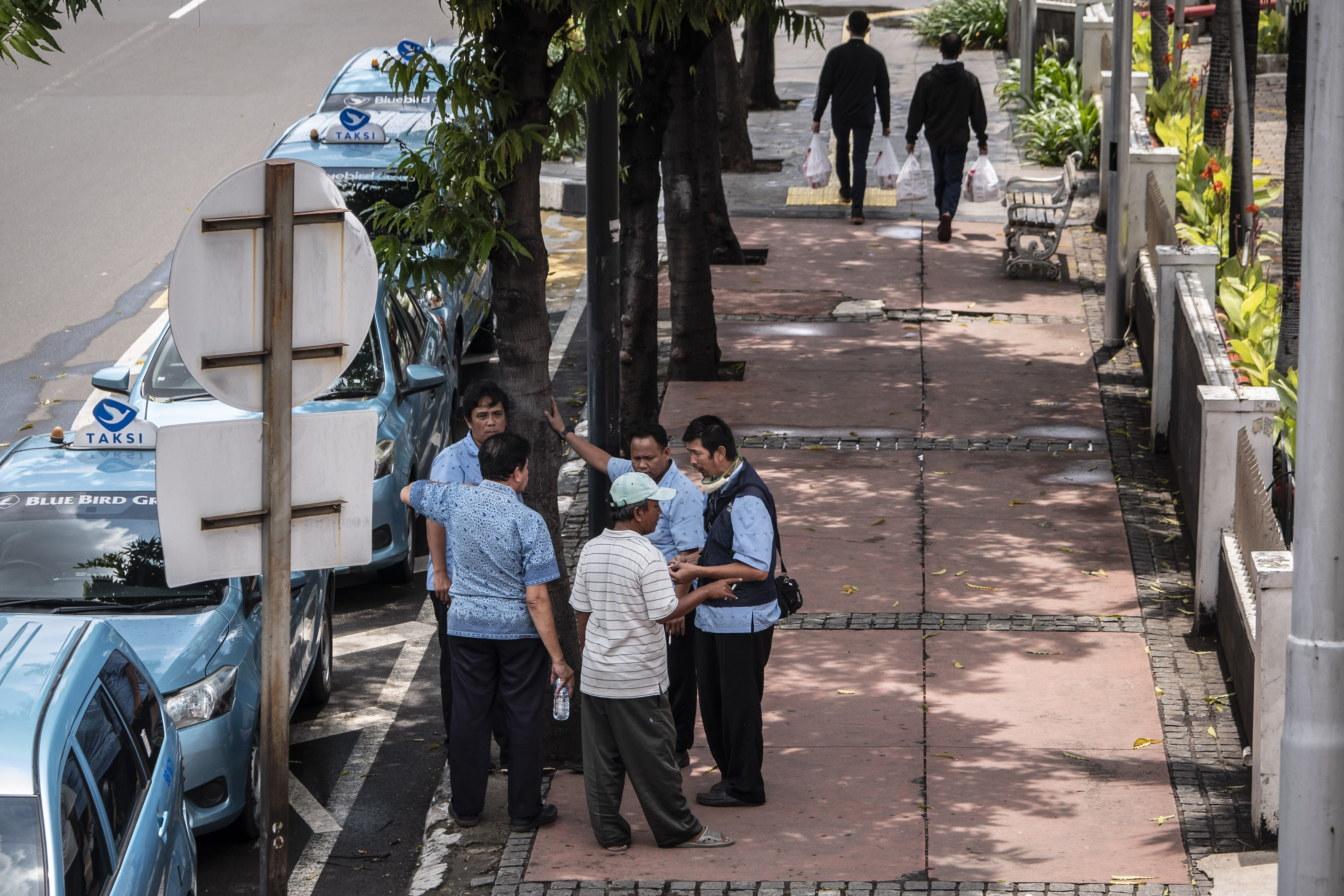Pengemudi taksi beraktivitas di trotoar Jalan MH Thamrin, Menteng, Jakarta, Rabu (8/4/2020).
