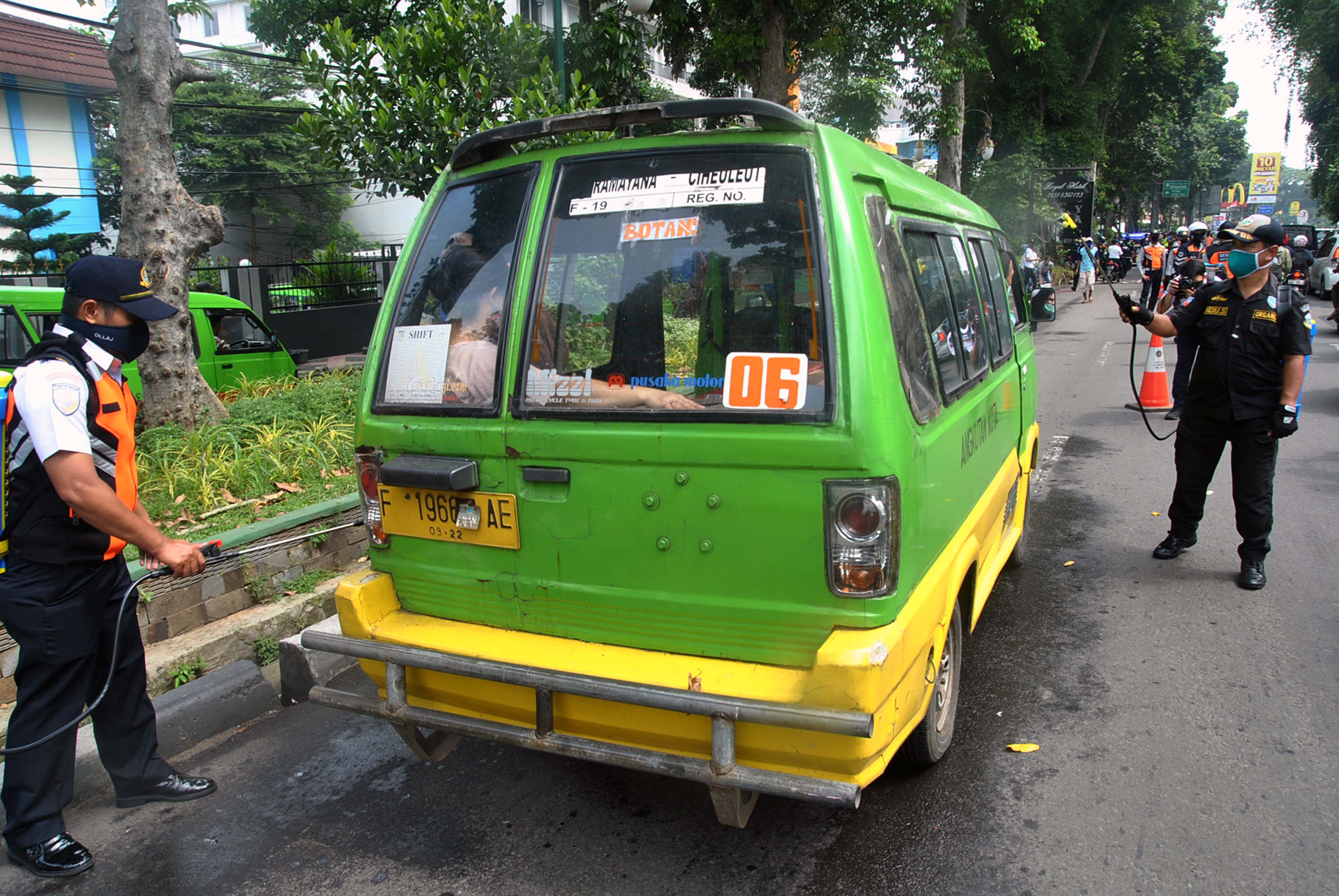 Petugas Dishub Kota Bogor menyemprot cairan disinfektan ke mobil angkot sebagai upaya pencegahan penyebaran virus korona.