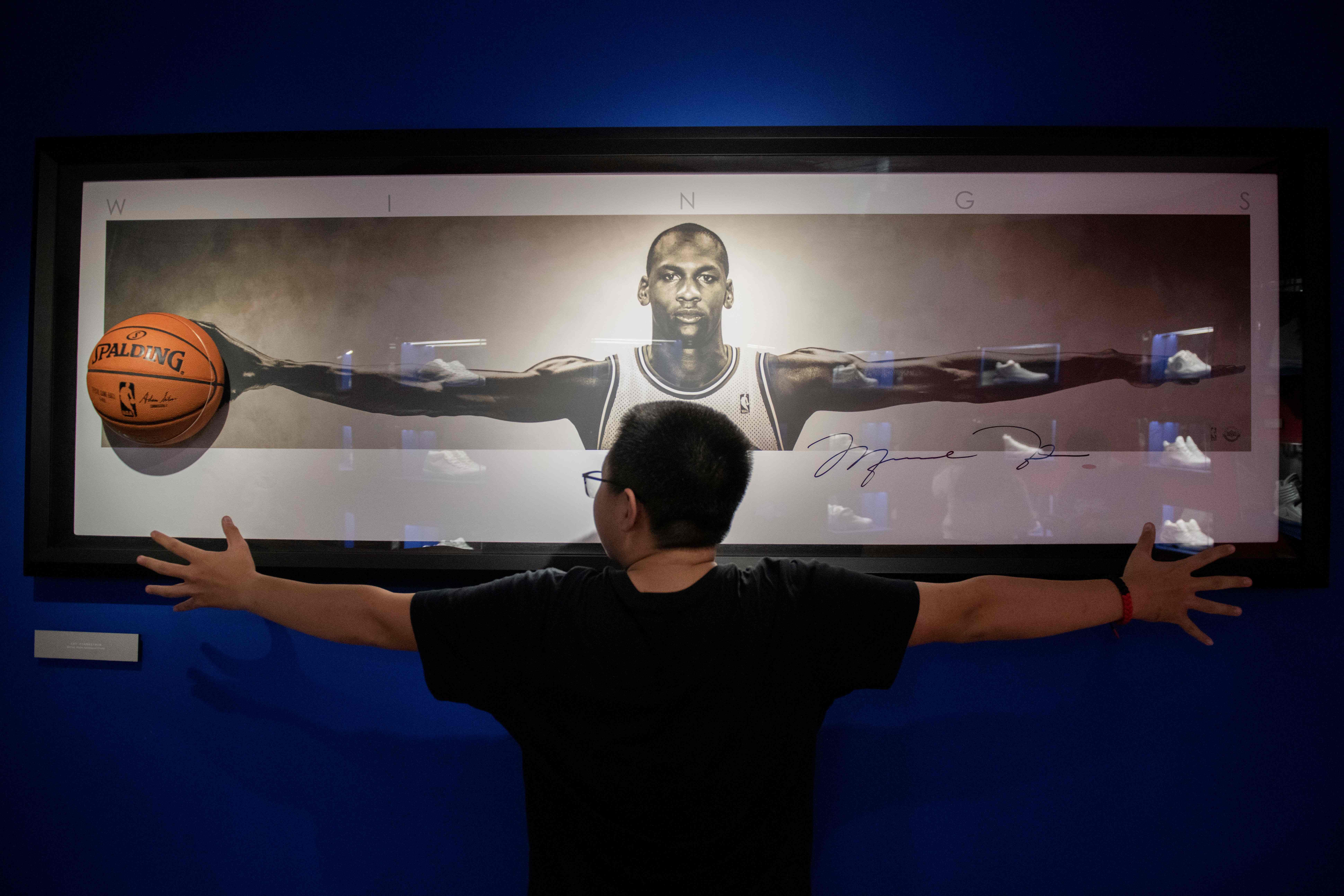 Seorang penggemar berfoto di depan gambar Michael Jordan.