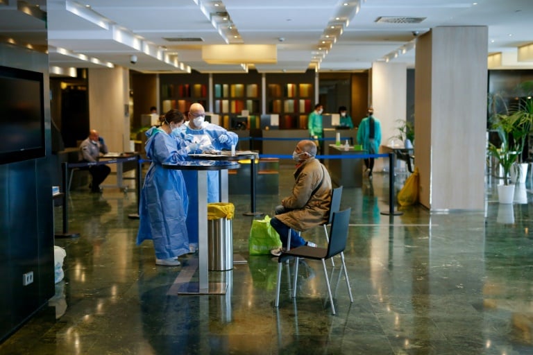 Pasien Covdi-19 disambut petugas medis di Hotel Melia Sarria, Barcelona, Spanyol, yang diubah menjadi karatina pasien Covid-19. 