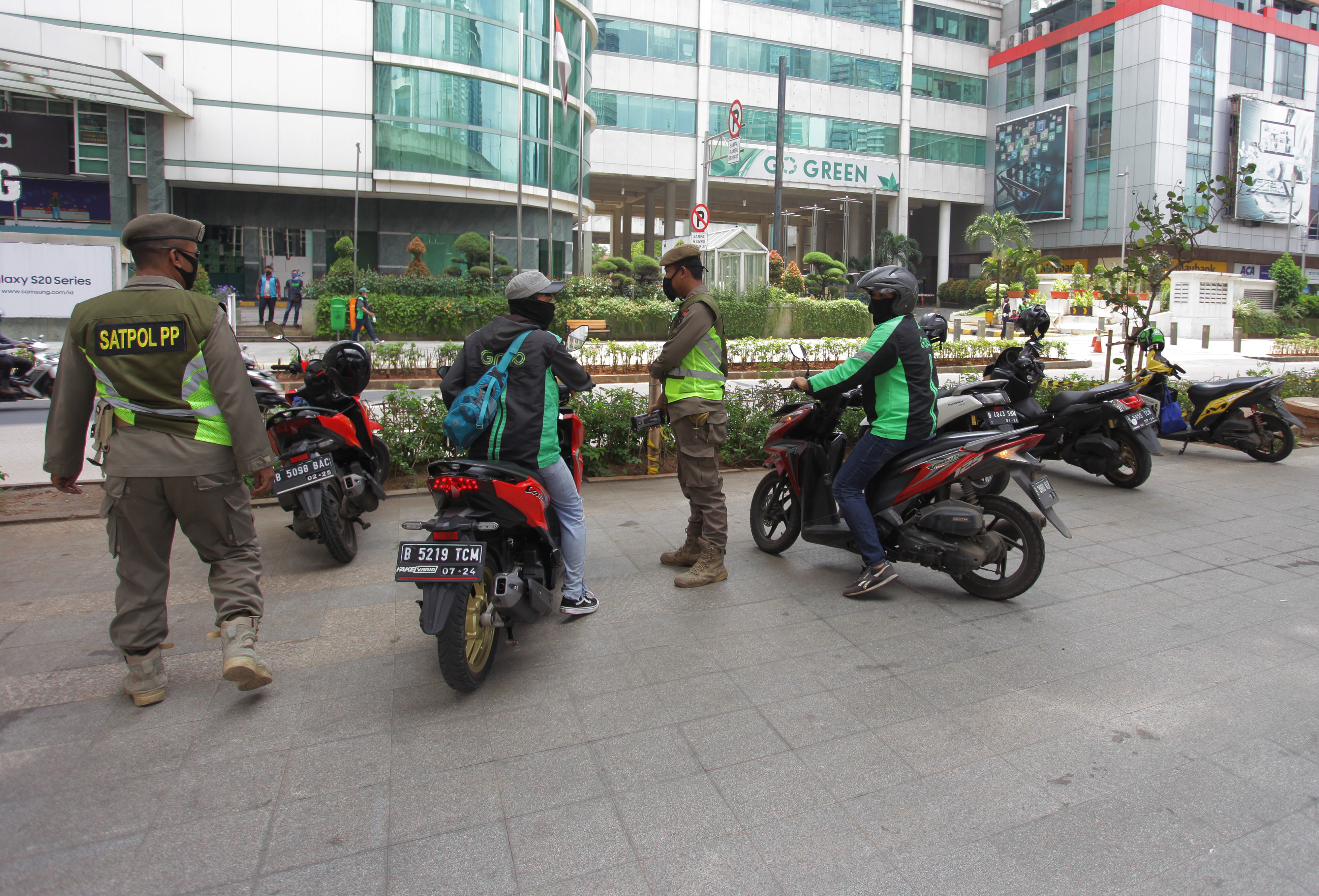Petugas Satpol PP Provinsi DKI Jakarta menertibkan ojeg online yang berkumpul di area Jalan Prof Dr Satrio, Jakarta, Senin (20/4).