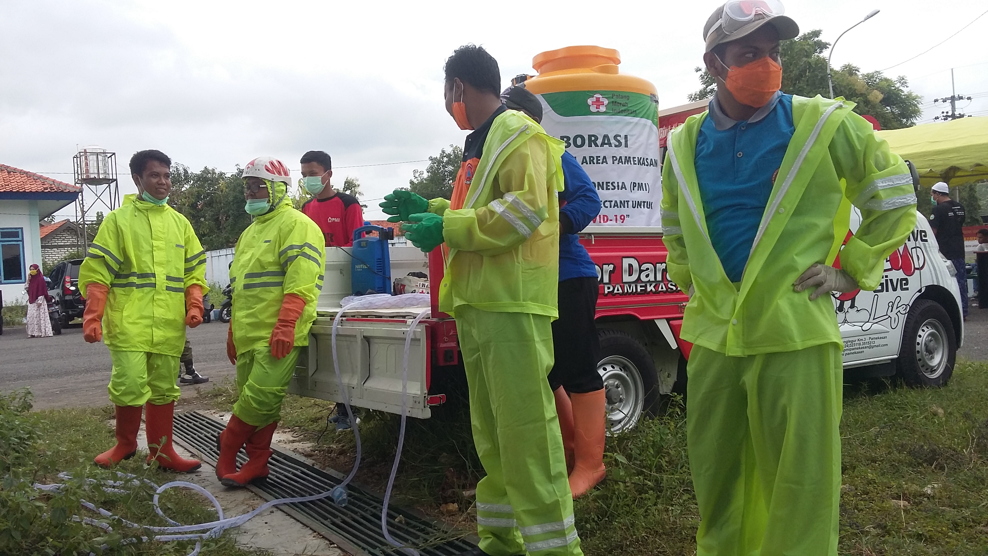 Relawan membantu Satgas Covid-19 Kabupaten Pamekasan, Jawa Timur, menyemprot kendaraan pemudik.