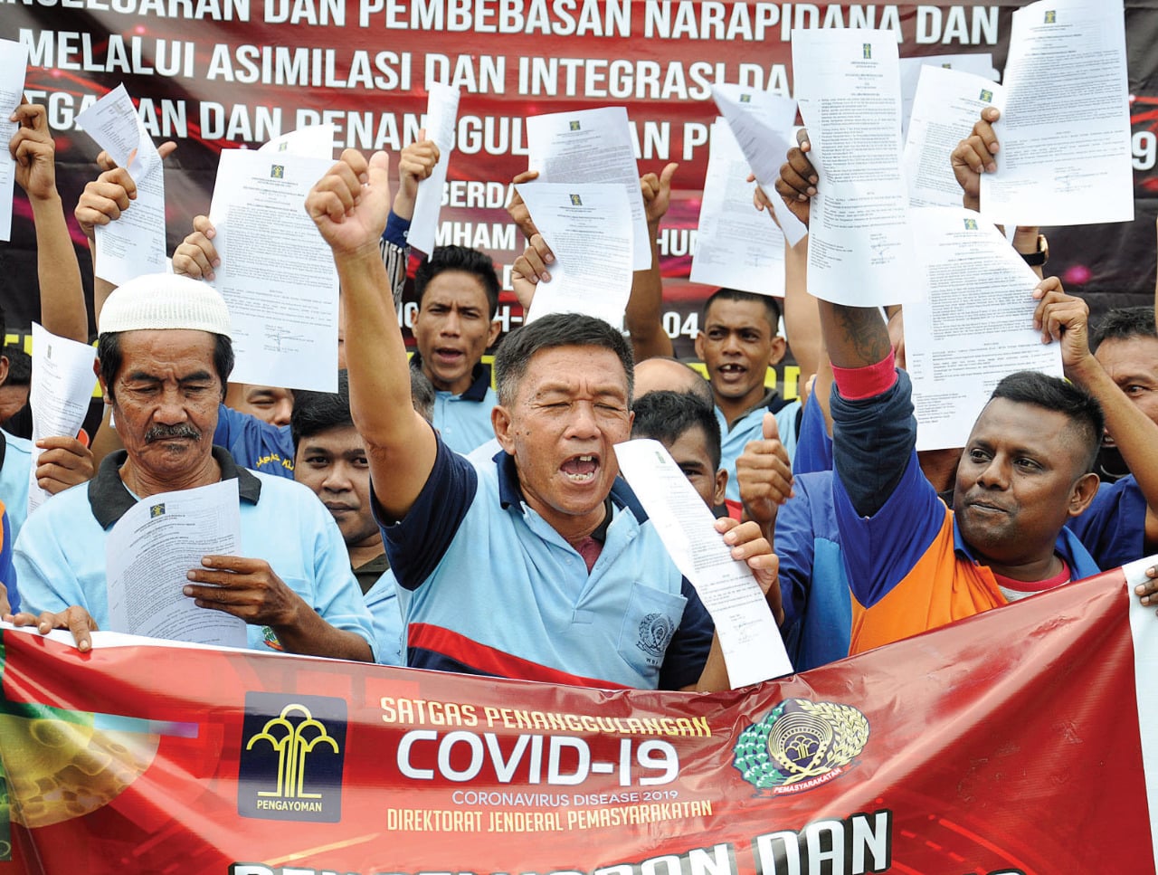 Sejumlah narapidana memperlihatkan surat pembebasan dari masa pidana di Lembaga Pemasyarakatan Kelas I Tanjung Gusta Medan, Sumatra Utara.