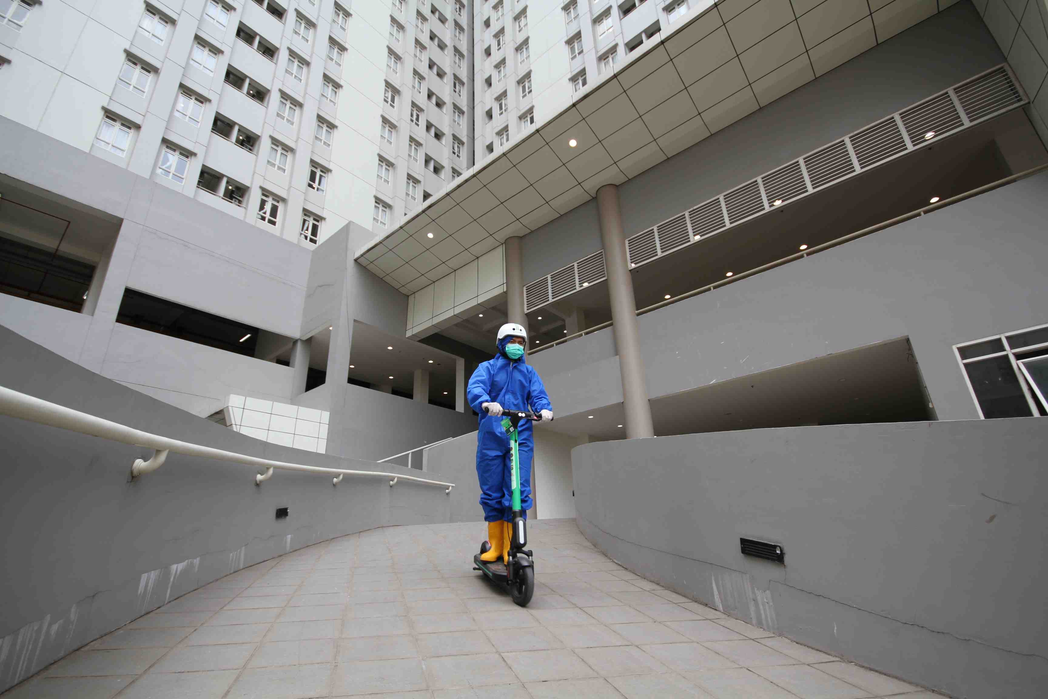 Petugas medis di Wisma Atlet sedang mengendarai GrabWheels. 