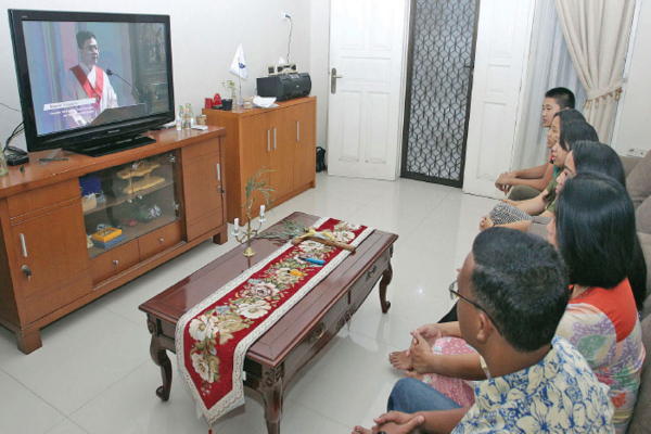Keluarga Katolik menjalani misa Jumat Agung secara daring di kediaman mereka di Jakarta, kemarin.