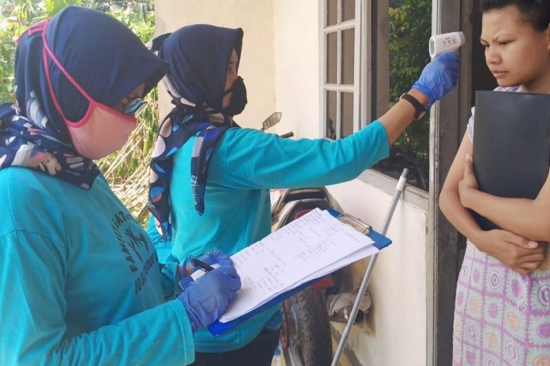 Relawan dari program Dasa Wisma mengecek suhu tubuh warga di Cilandak, Jakarta Selatan