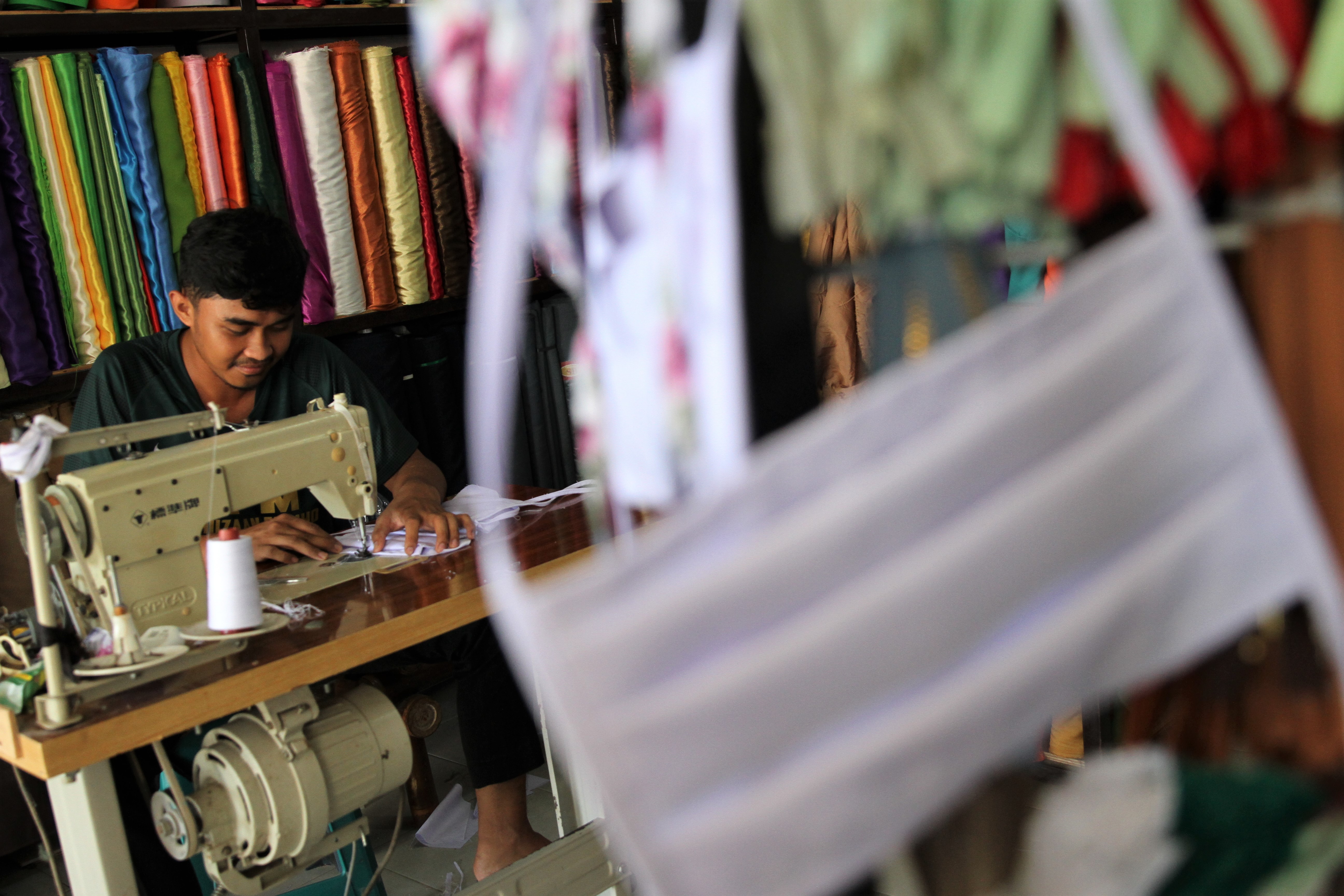 Ilustrasi penjahit yang memproduksi masker kain.