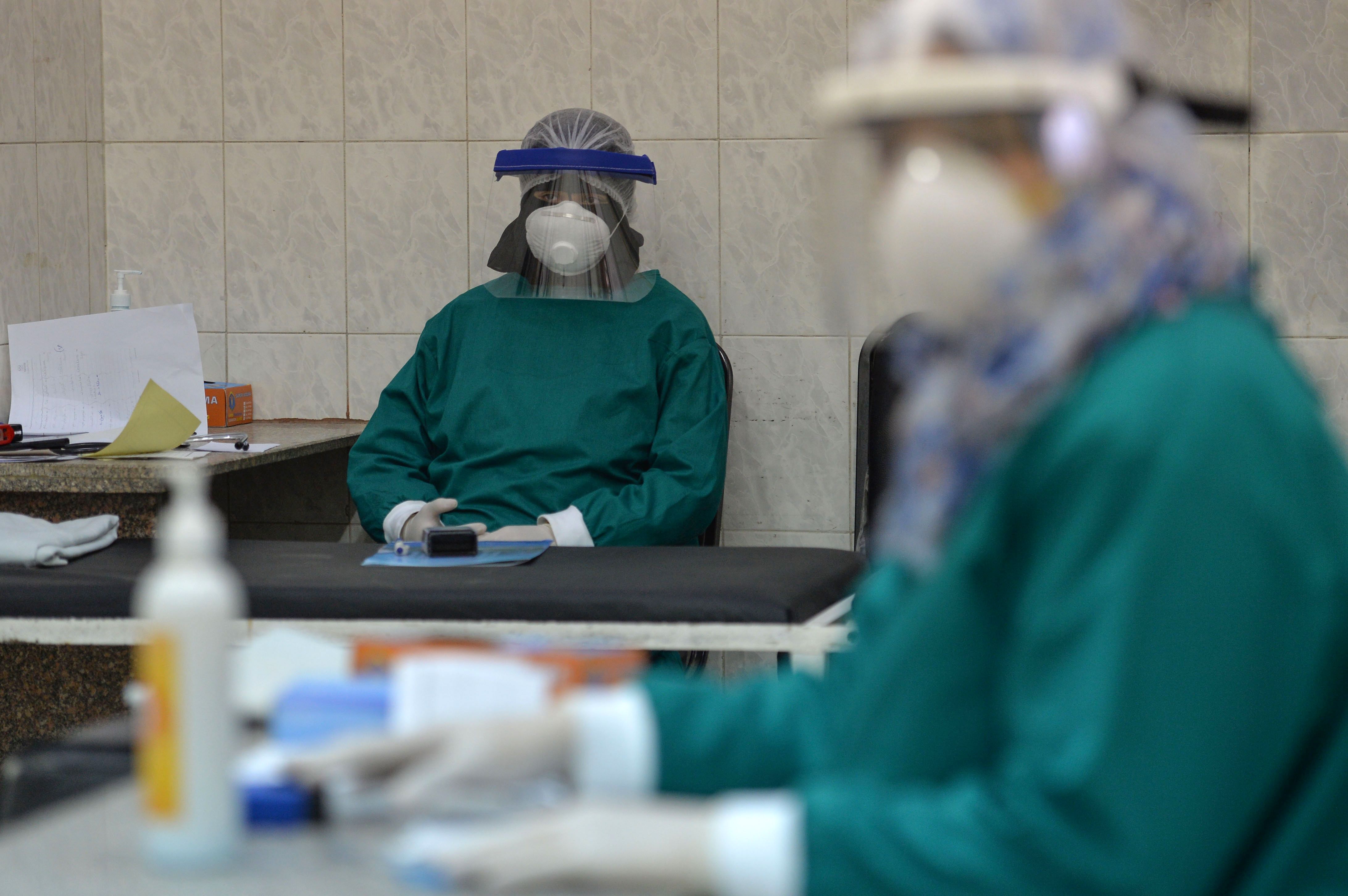 Petugas kesehatan di Rumah Sakit Imbaba, Kairo, Mesir beristirahat setelah menangani pasien covid-19.