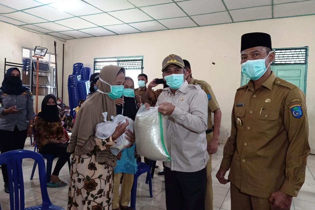 Bupati OKI Iskandar membagikan sembako kepada masyarakat miskin terdampak covid-19.