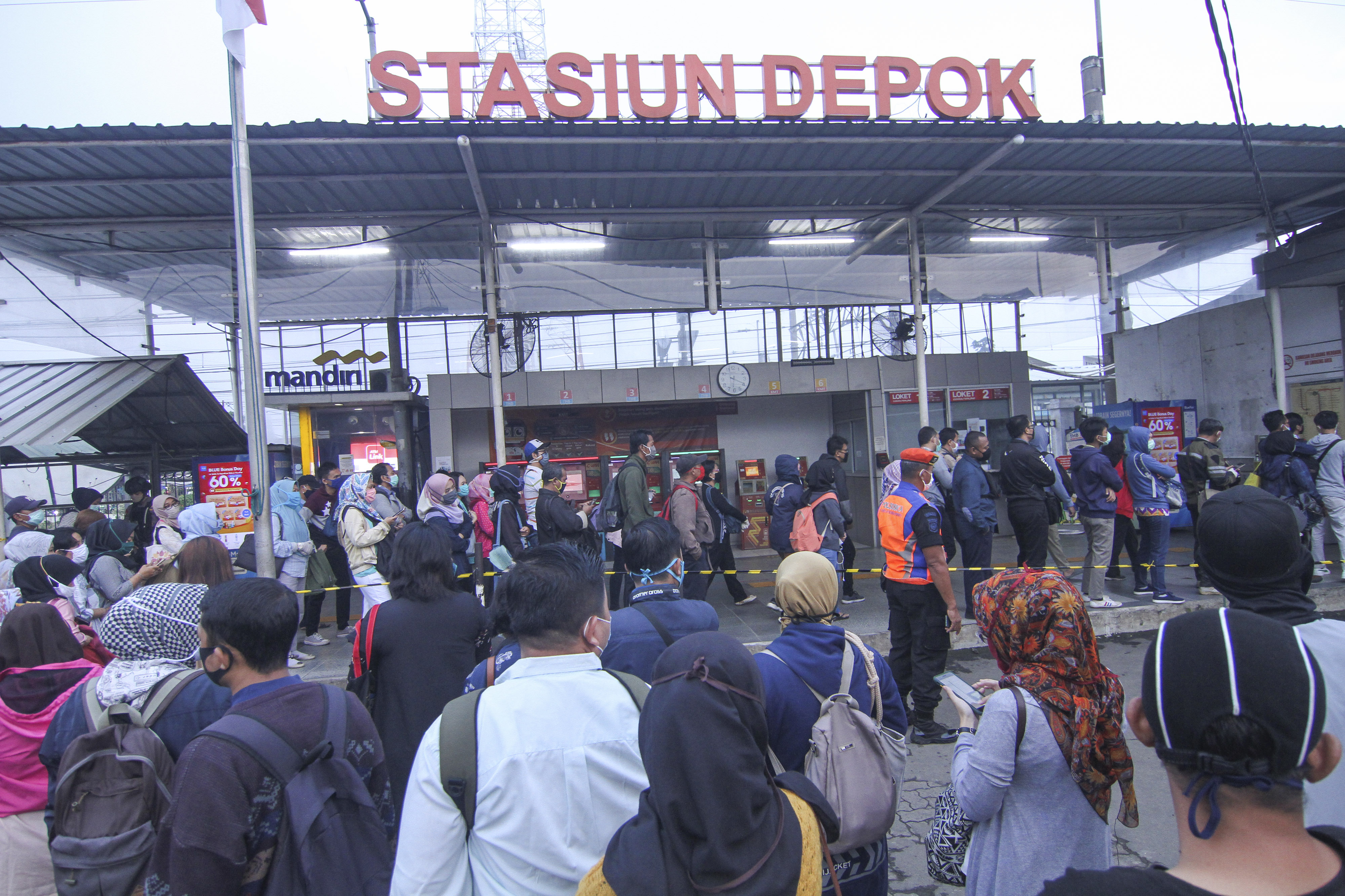 Calon penumpang KRL Commuter Line antre menunggu kedatangan kereta di Stasiun Depok Lama, Depok, Jawa Barat, hari ini.