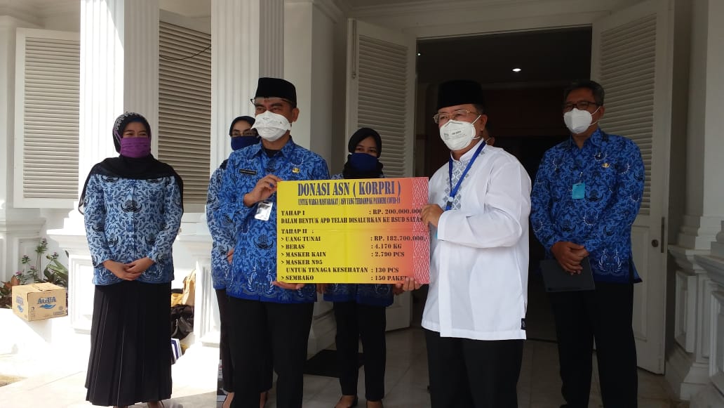 Kepala DPK Korpri Kabupaten Cianjur, Cecep Alamsyah  menyerahkan donasi kepada Plt Bupati Cianjur, Herman Suherman (kemeja putih)