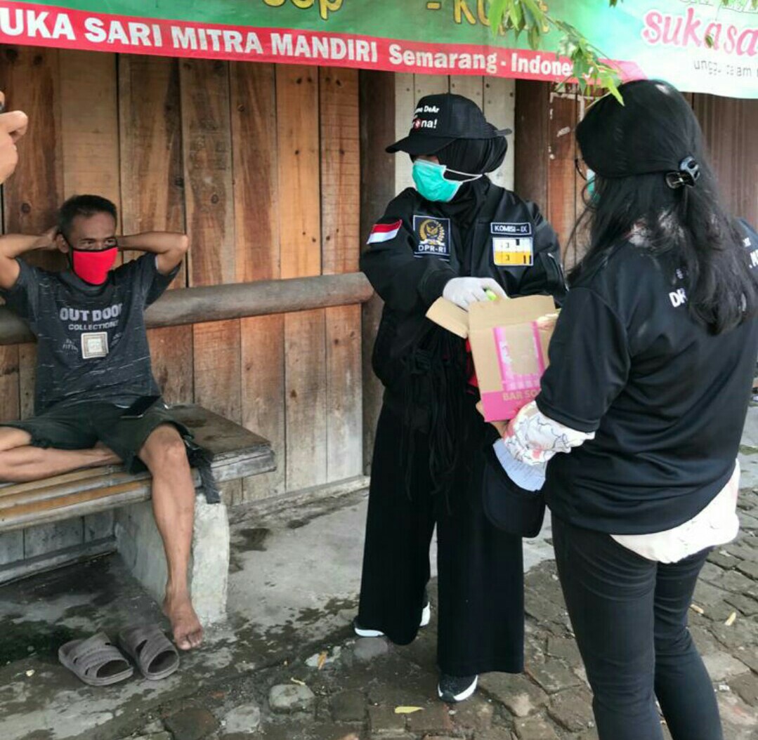 Legislator Dewi Aryani membagikan masker kepada warga.
