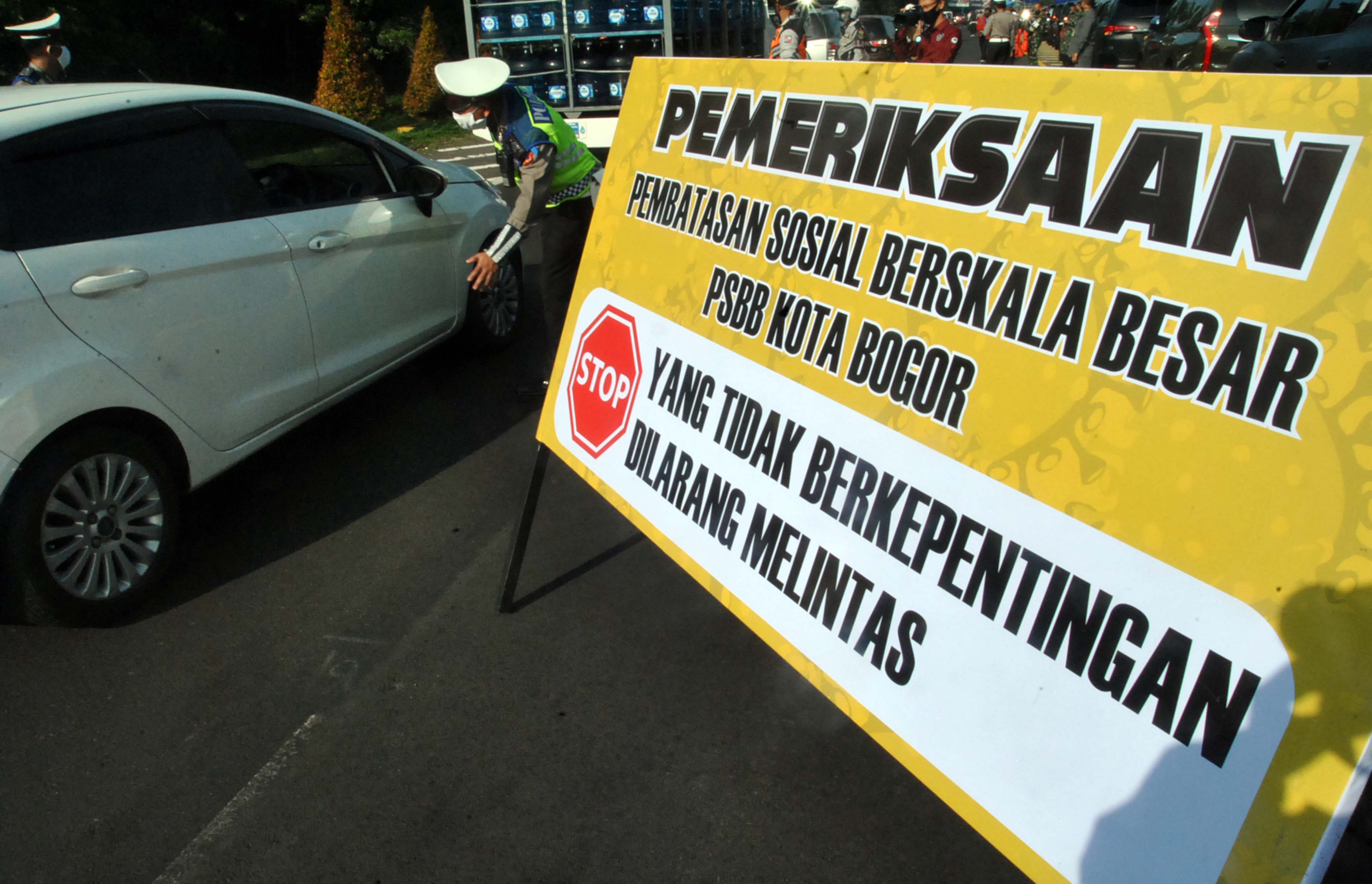 Anggota Polresta Bogor Kota mengatur lalu lintas saat pelaksanaan PSBB di pos check point pintu keluar Tol Jagorawi, Kota Bogor.